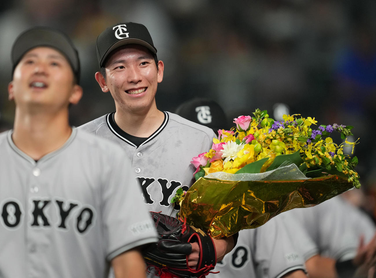 阪神対巨人　ノーヒットノーランを達成し、花束を手に笑顔を見せる巨人戸郷（右）（撮影・菅敏）