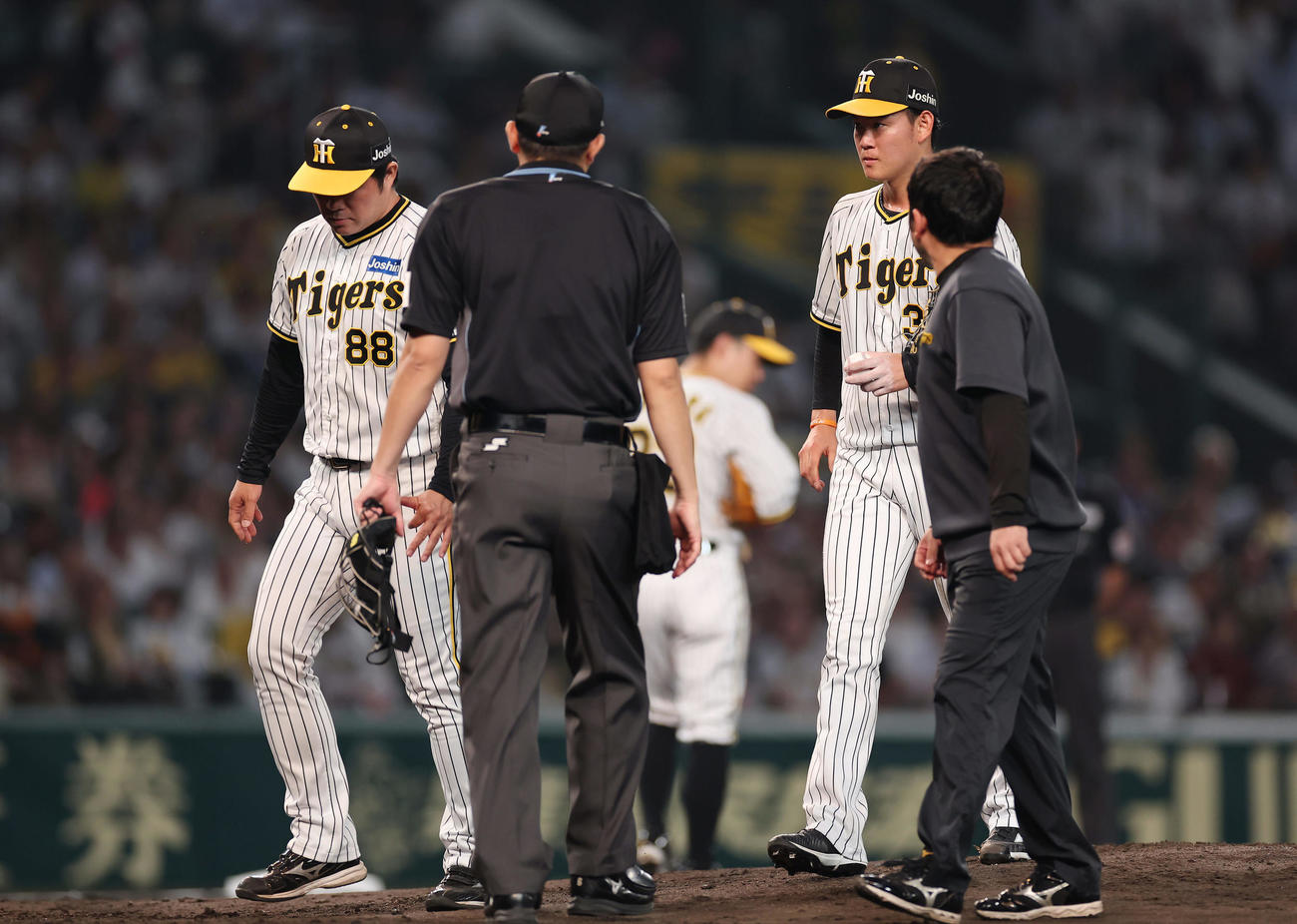 阪神対巨人　5回表巨人1死一塁、安藤投手コーチ（左）と一緒にマウンドを降り治療に向かう及川（右から2人目）（撮影・前田充）