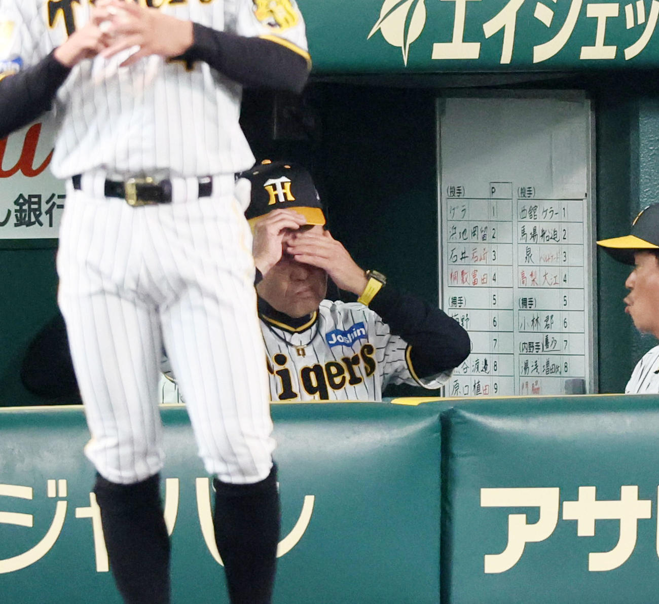 阪神対巨人　6回表を終えベンチで帽子を取る岡田監督（撮影・加藤哉）