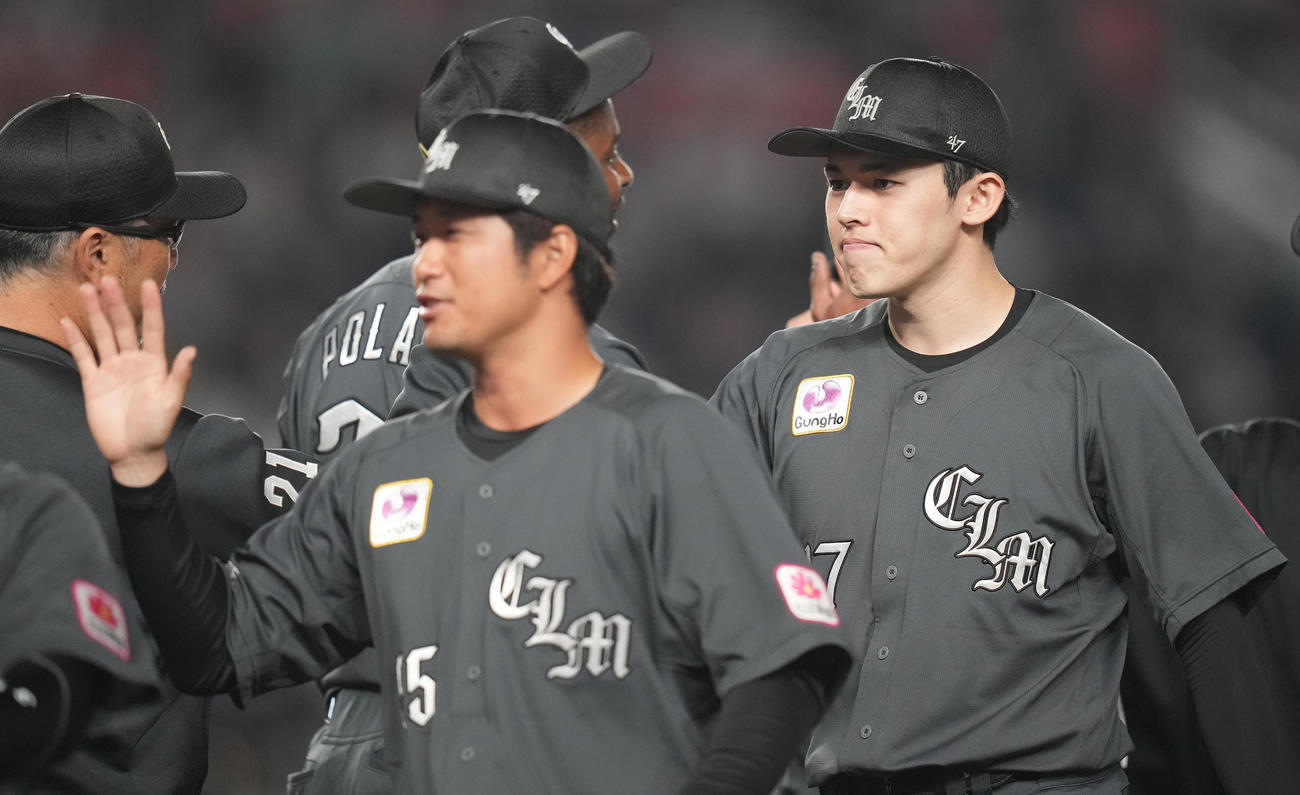 ロッテ対ソフトバンク　ソフトバンクに勝利し、吉井監督（左）とタッチを交わすロッテ佐々木（撮影・鈴木みどり）