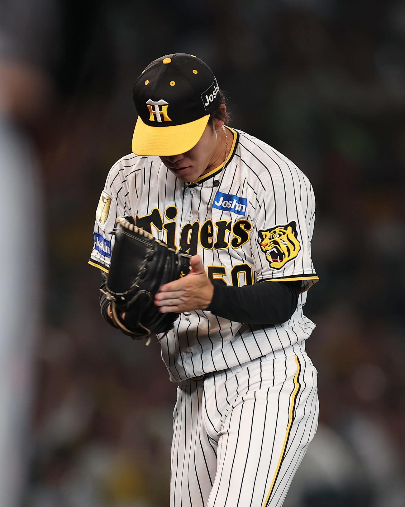 阪神対巨人　7回表巨人2死一、三塁、坂本を空振り三振に仕留めグラブをたたく富田（撮影・前田充）