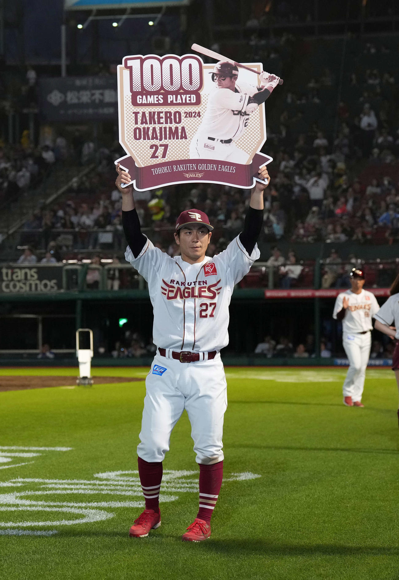 楽天対日本ハム　通算1000試合出場の楽天岡島は記念のボードを掲げる（撮影・井上学）