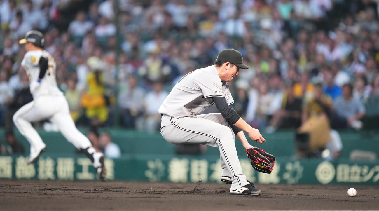 阪神対巨人　3回裏阪神2死、及川（後方）の打球を処理するも一塁に送球エラーをする戸郷（撮影・菅敏）