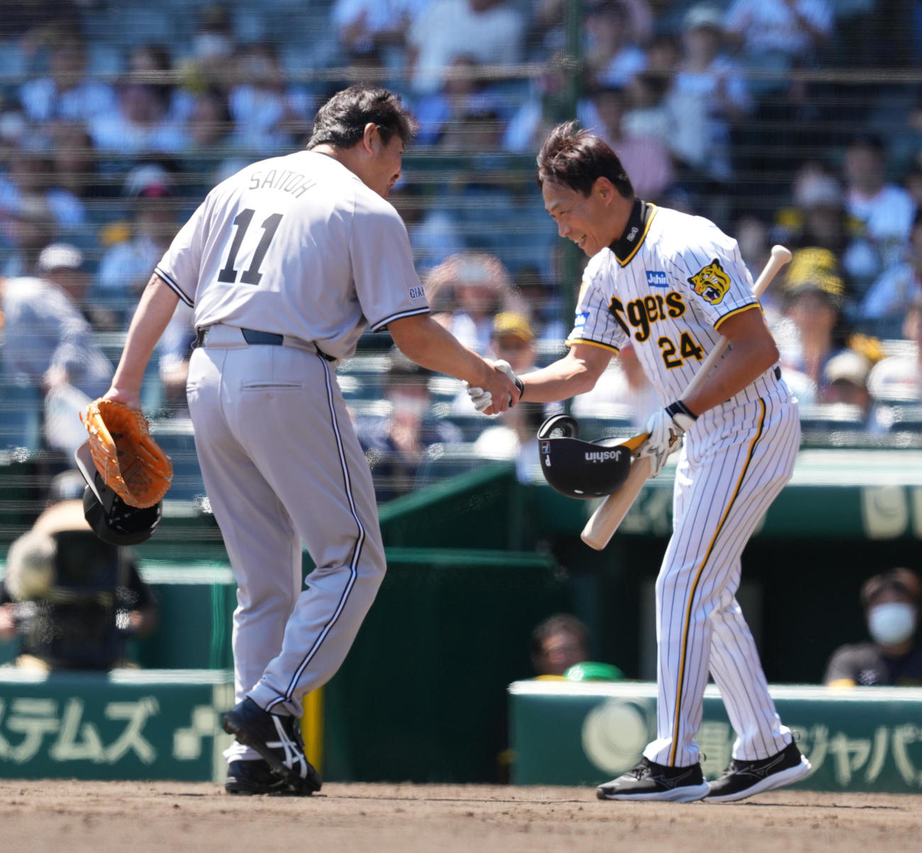 阪神対巨人　ファーストピッチセレモニーで対決した元阪神桧山氏（右）と握手をする元巨人斎藤氏（撮影・菅敏）