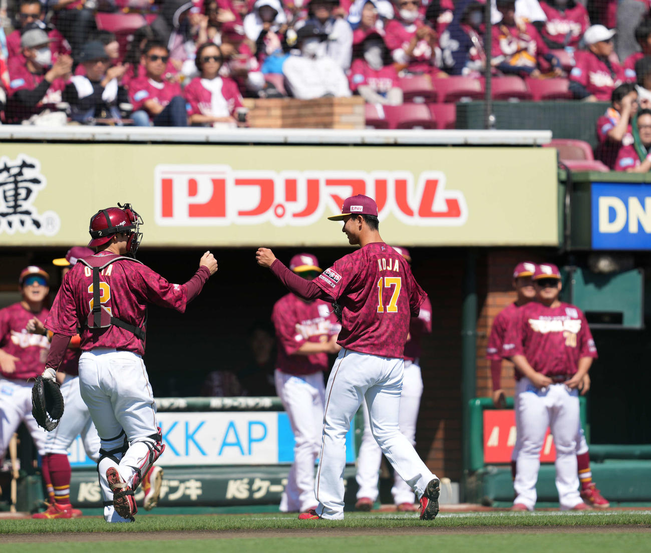 楽天対日本ハム　1回を終え、太田（左）とタッチをする古謝（撮影・井上学）（撮影・井上学）