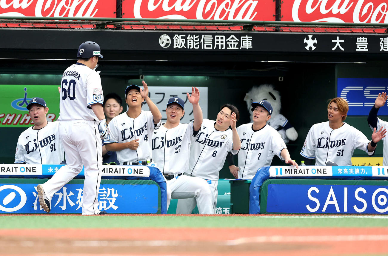 西武対オリックス　2回裏西武無死、左越え先制ソロ本塁打で生還する中村剛（左から2人目）を迎えるチームメート（撮影・河田真司）