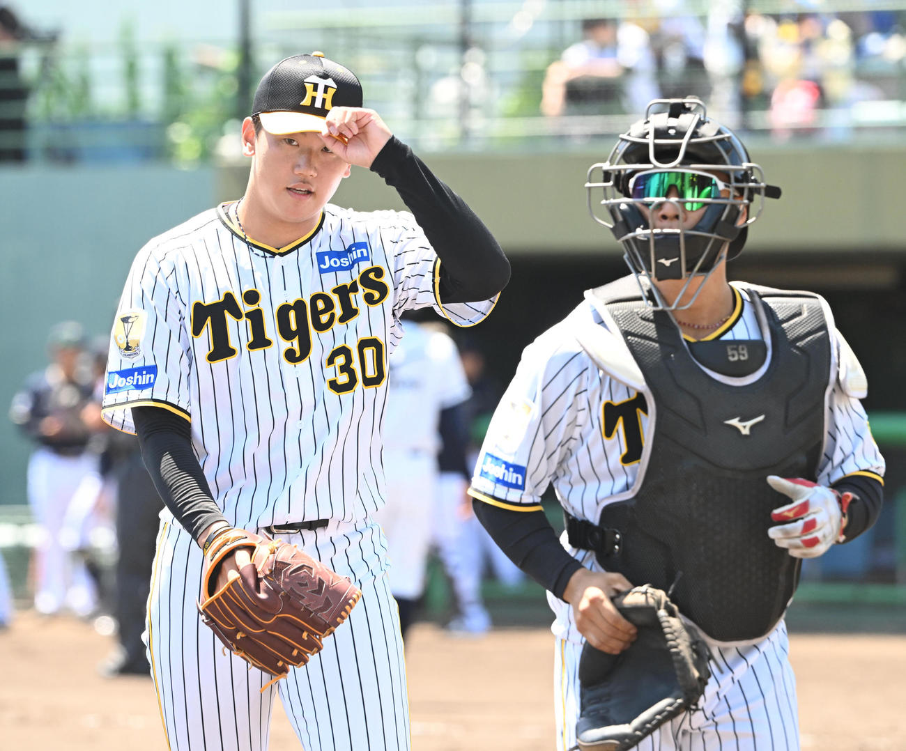 2軍阪神対オリックス　5回まで無失点としさっそうとベンチに戻る阪神門別、右は藤田（撮影・和賀正仁）