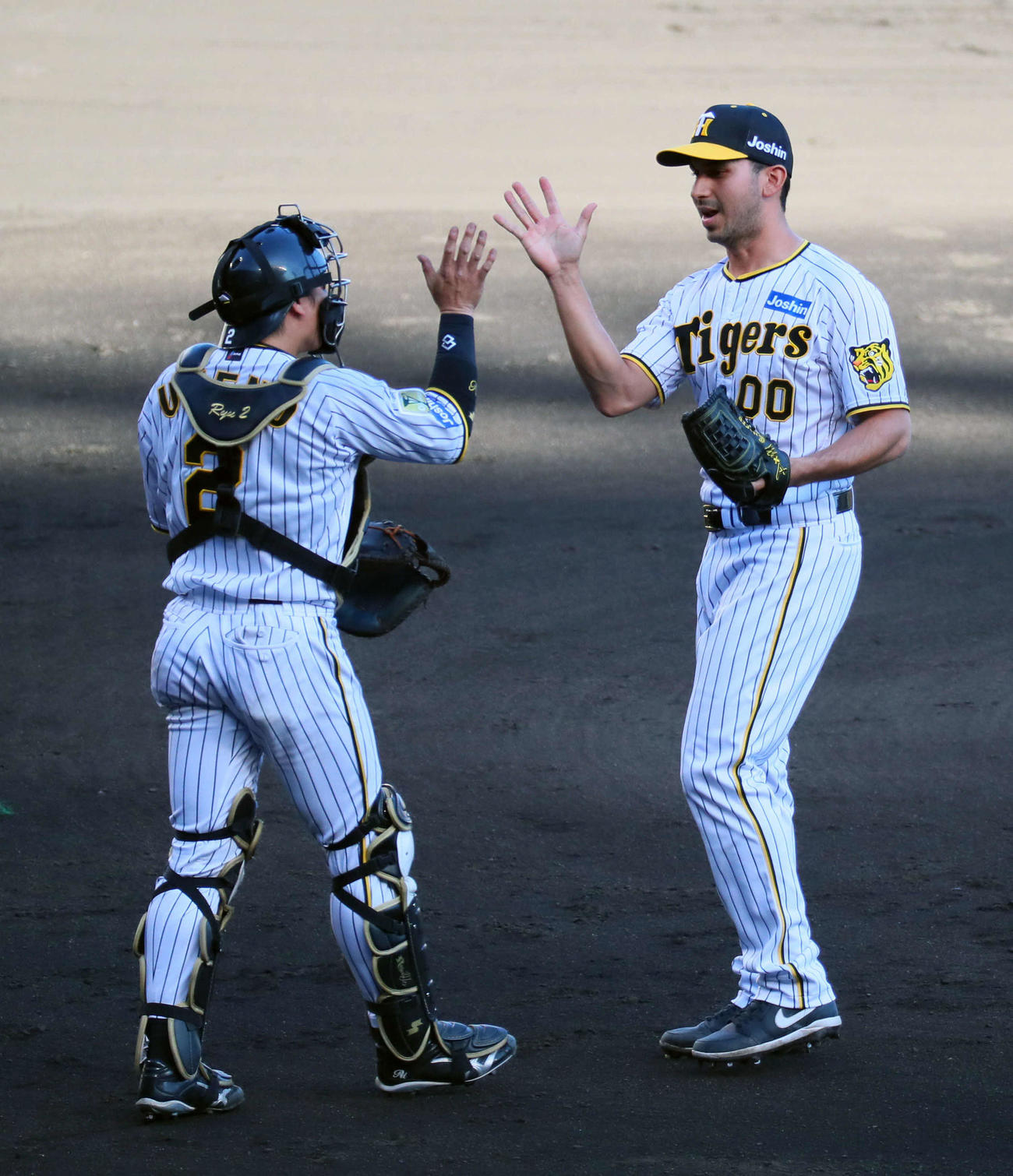 阪神対巨人　最後を締めてハイタッチする梅野（左）とゲラ（撮影・宮崎幸一）