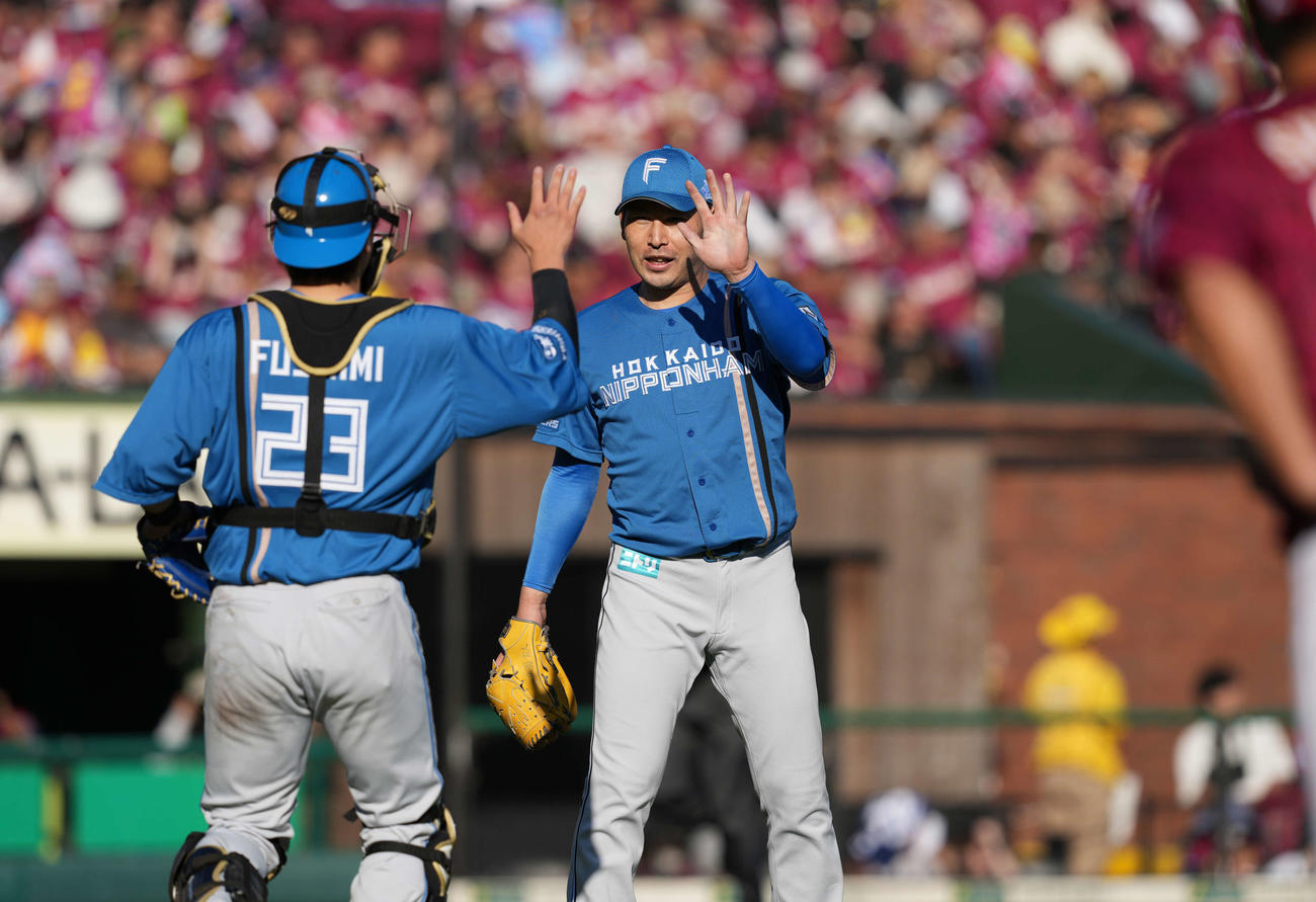 楽天対日本ハム　完封勝利を挙げ伏見（左）とタッチする加藤貴（撮影・井上学）