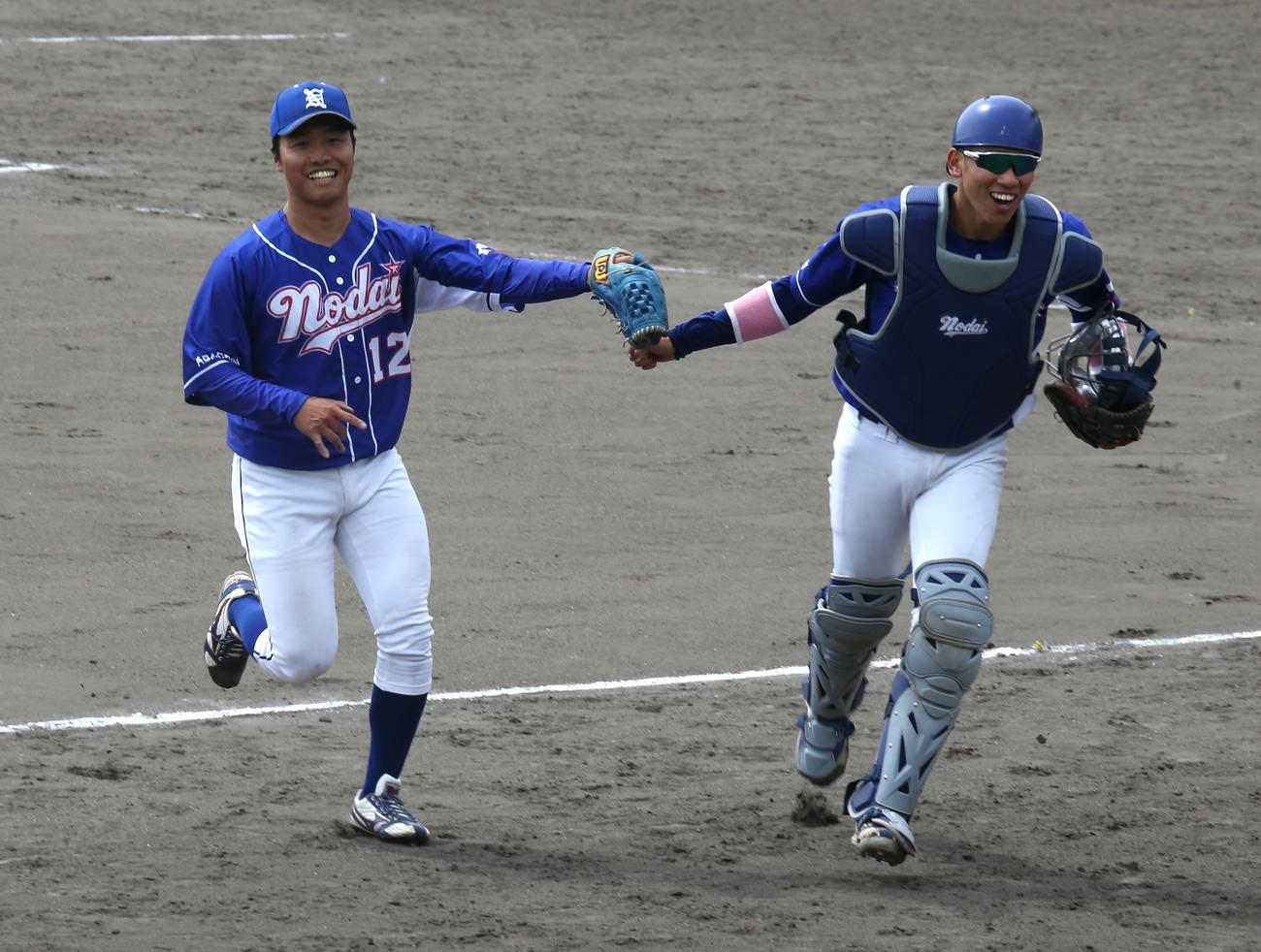 東農大北海道対旭川市大　7回裏旭川市大2死満塁、東農大北海道の渡辺（左）はピンチを無失点にしのぎ、千葉捕手と笑顔でグラブタッチ（撮影・中島洋尚）