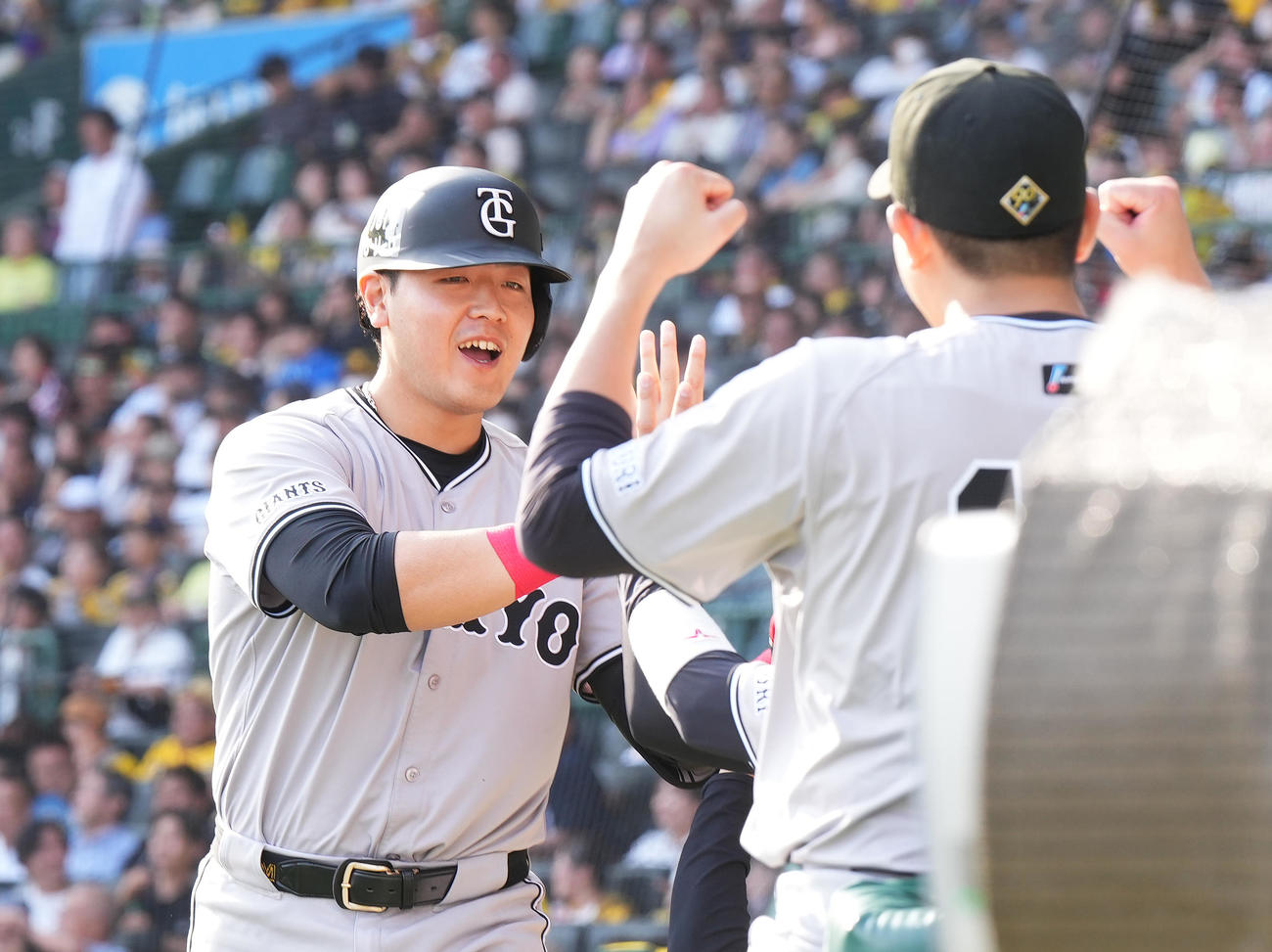 阪神対巨人　9回表巨人1死、左中間に同点のソロ本塁打を放ち、菅野（手前）に迎えられる岡本和（撮影・菅敏）