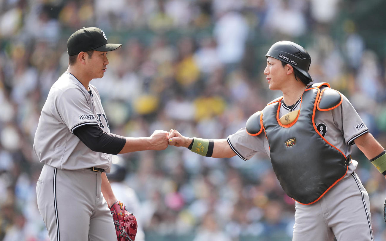阪神対巨人　4回の投球を終え、捕手小林（右）とタッチをする菅野（撮影・菅敏）