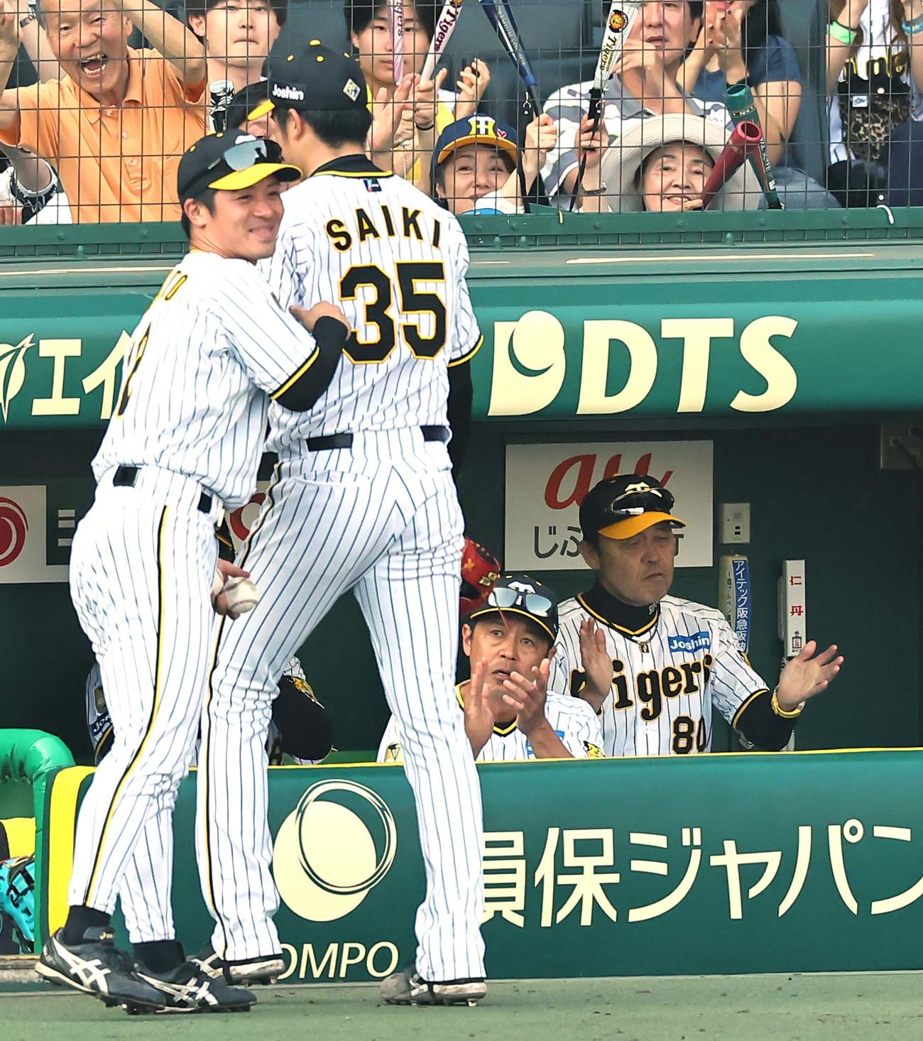 阪神対巨人　岡田監督（右）は8回途中無失点で降板する才木に拍手を送る（撮影・上田博志）