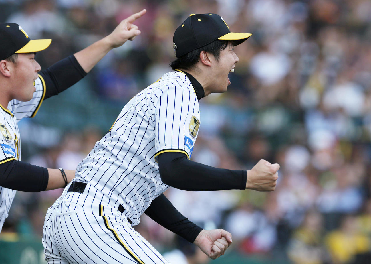 阪神対巨人　8回表巨人2死三塁、3番手の石井が坂本を三ゴロに仕留め、ベンチを飛び出しガッツポーズする才木。左は桐敷（撮影・前田充）
