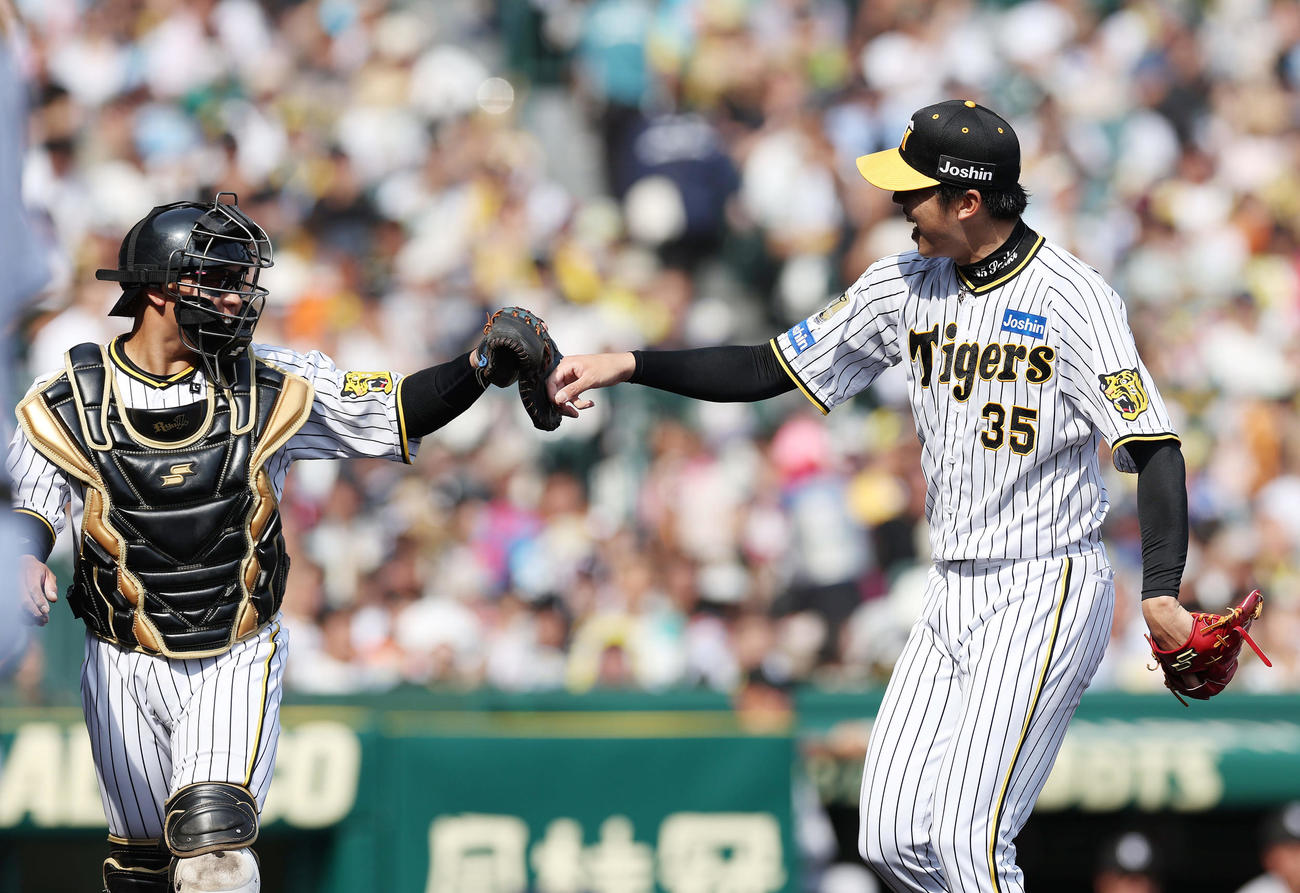 阪神対巨人　6回表巨人2死一、二塁、岡本和を右飛に仕留めタッチを交わす梅野（左）と才木（撮影・前田充）