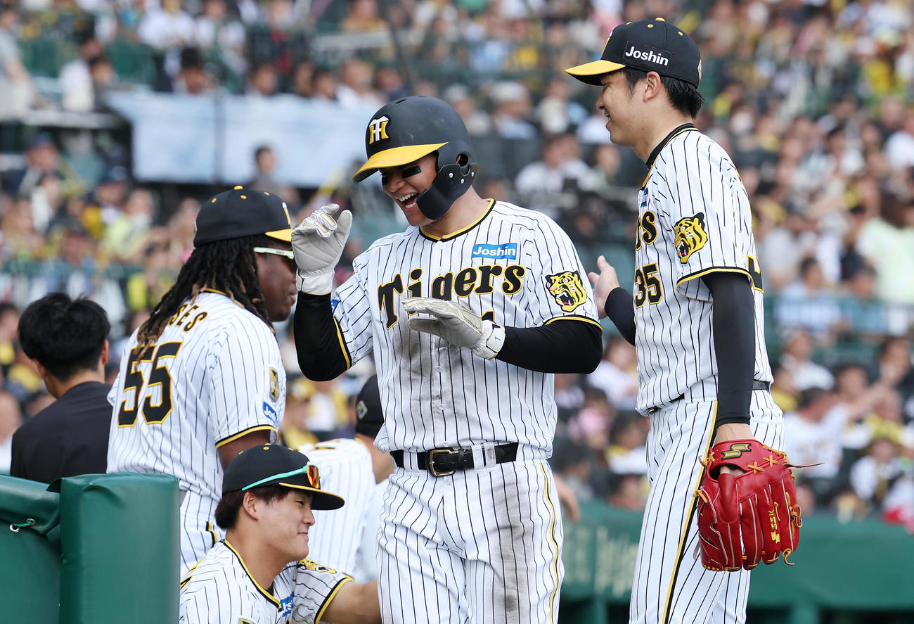 阪神対巨人　7回裏阪神1死一、三塁、渡辺の先制適時打で生還し、才木（右）らナインに迎えられる森下（中央）（撮影・前田充）