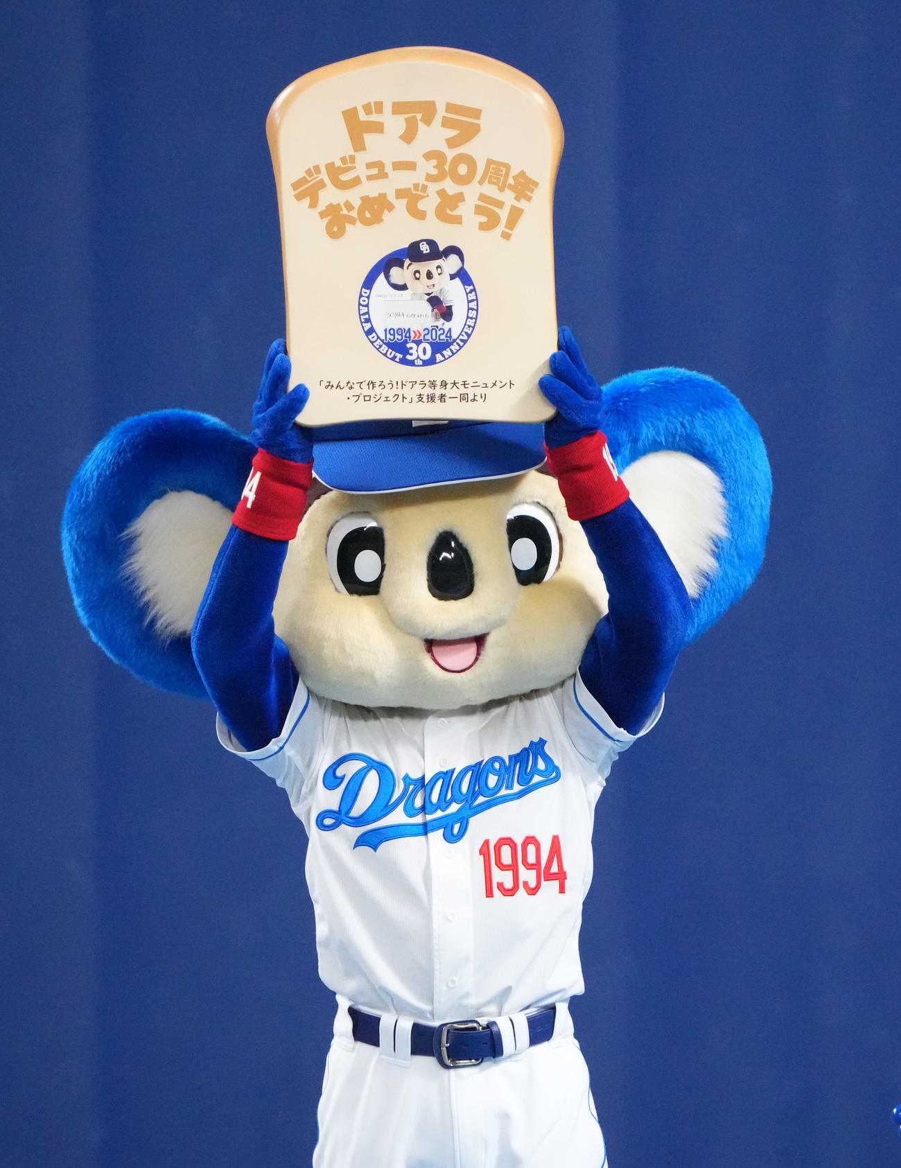 中日対ヤクルト　試合後行われた30周年イベントで等身大モニュメント支援者一同から食パン型プレートを受け取るドアラ（撮影・森本幸一）