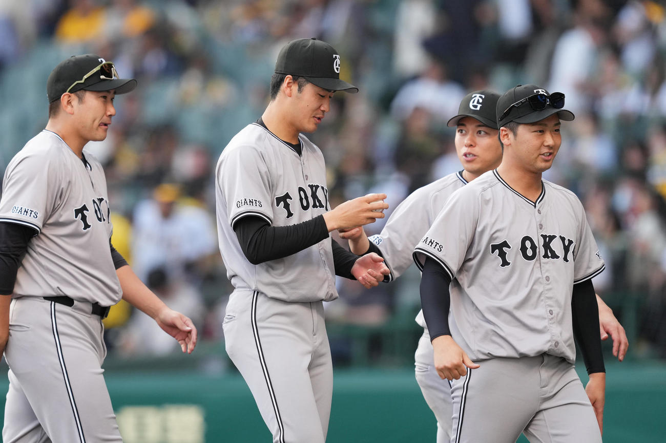 阪神対巨人　プロ初勝利を挙げ、受け取ったウイニングボールを見つめる巨人西舘（中央）（撮影・菅敏）