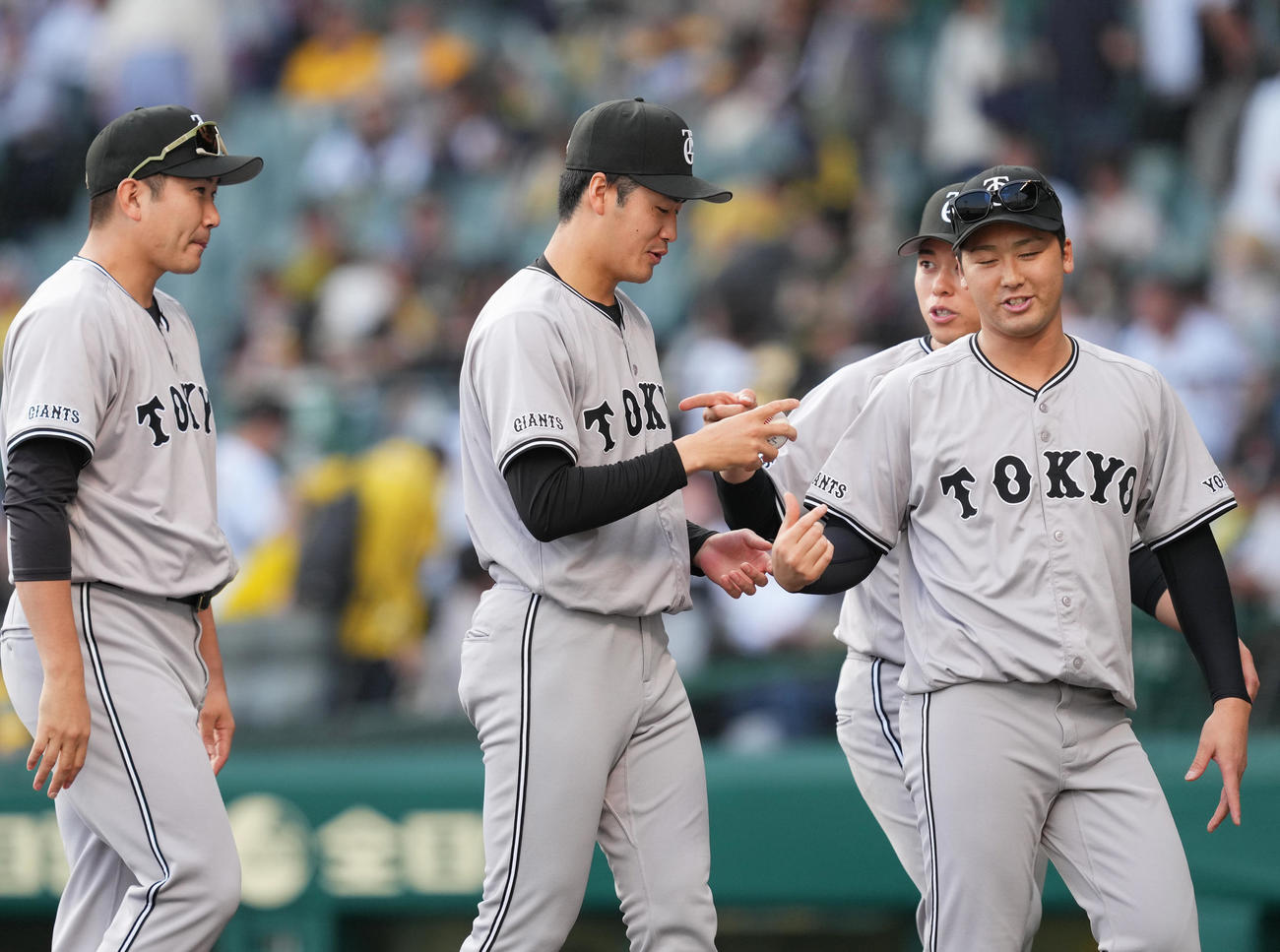 阪神対巨人　プロ初勝利を挙げ、受け取ったウイニングボールを見つめる巨人西舘（中央）（撮影・菅敏）