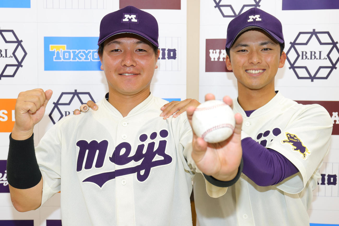 法大対明大　決勝本塁打の明大・中山（左）は、宗山主将に肩をもまれ記念球を手にガッツポーズ（撮影・野上伸悟）