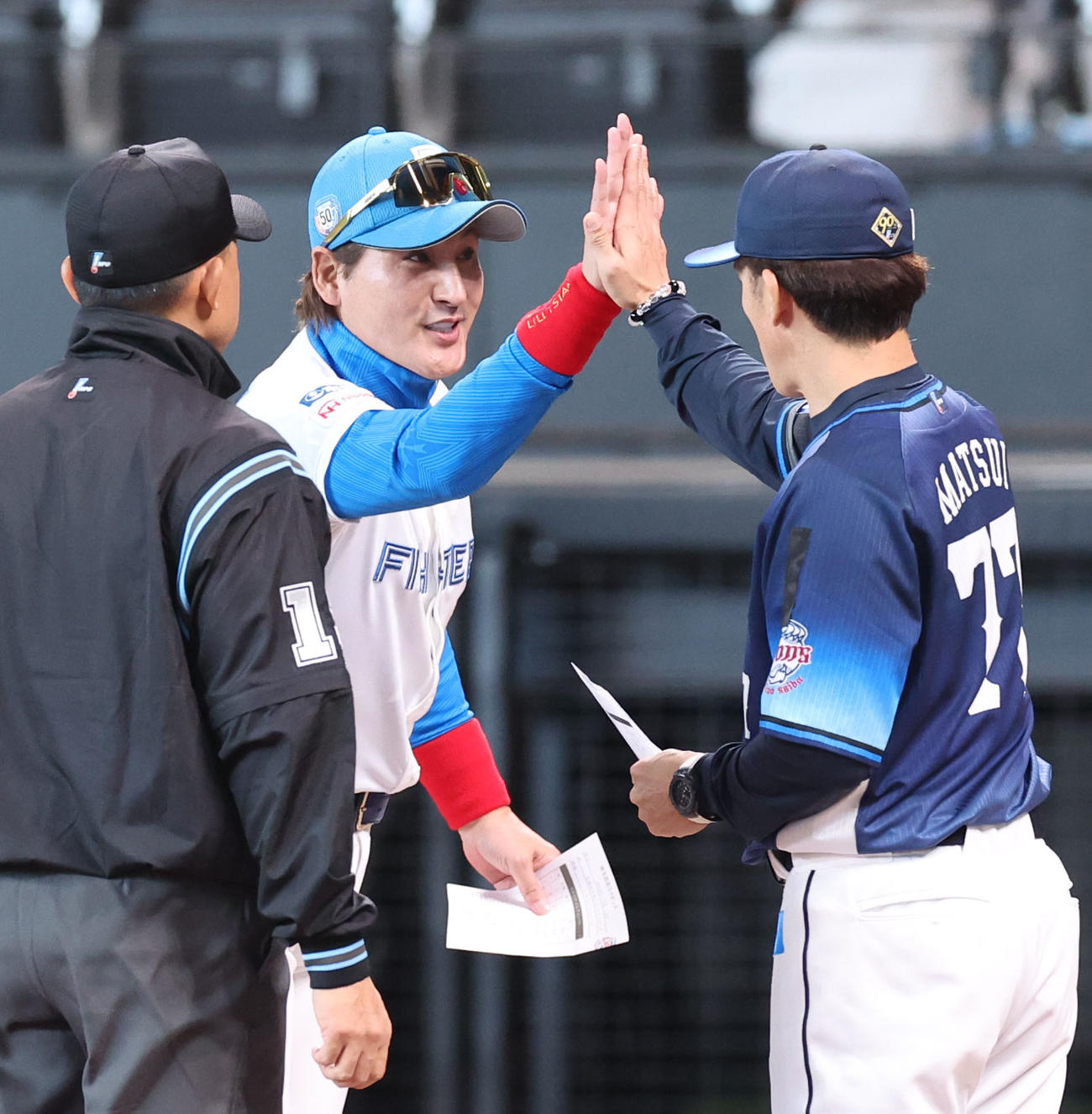 西武松井監督と「ハイタッチ・メンバー表交換」を行う日本ハム新庄監督（2024年5月24日撮影）