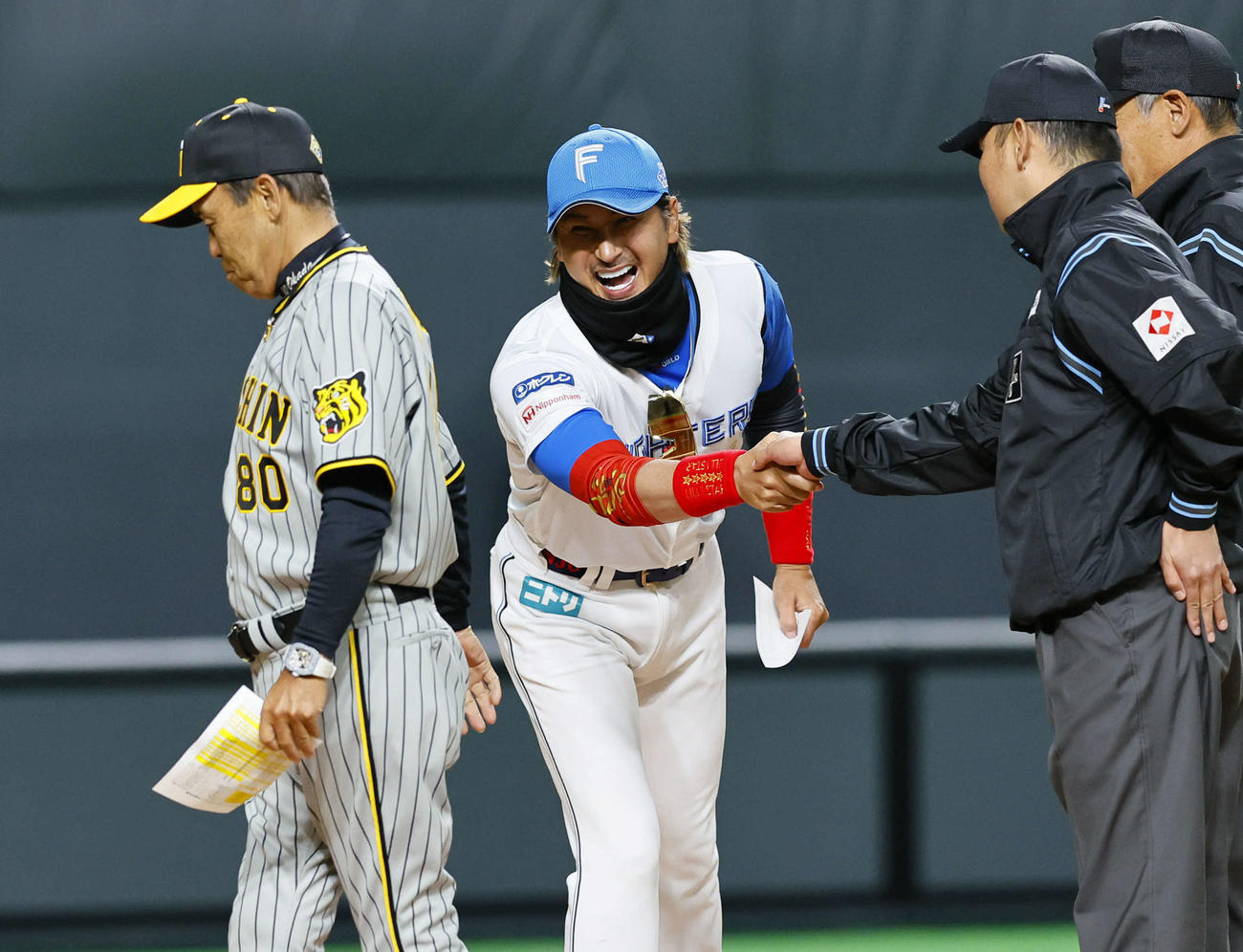 3月3日のオープン戦、試合前のメンバー表交換で阪神岡田監督（左）と言葉を交わし笑顔を見せる日本ハム新庄監督