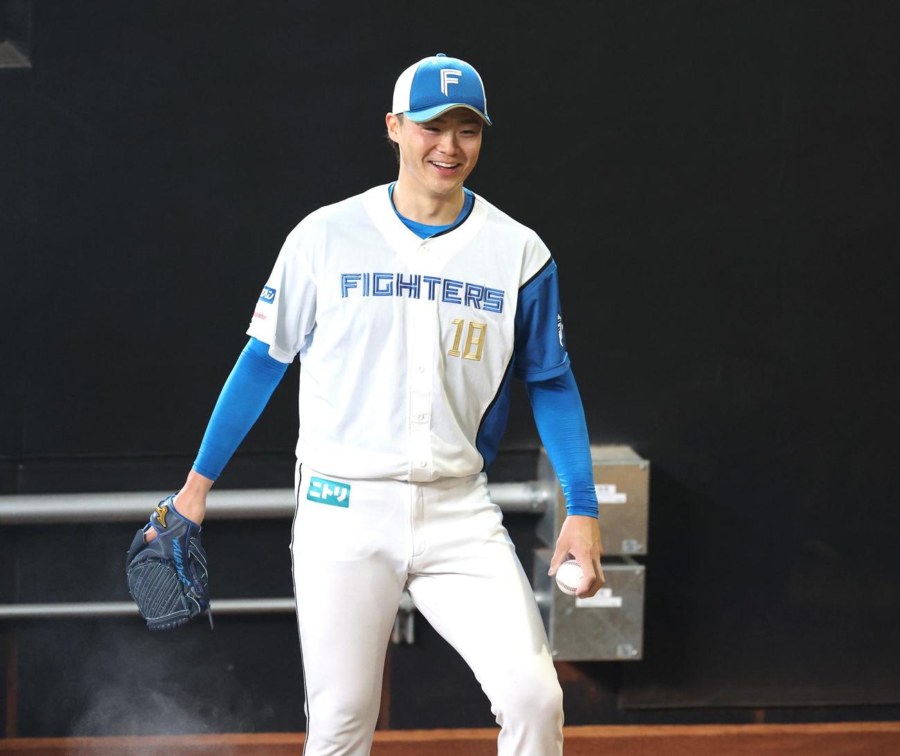 26日にエスコンフィールドのブルペンで投球中、笑顔を見せる日本ハム山崎（撮影・黒川智章）