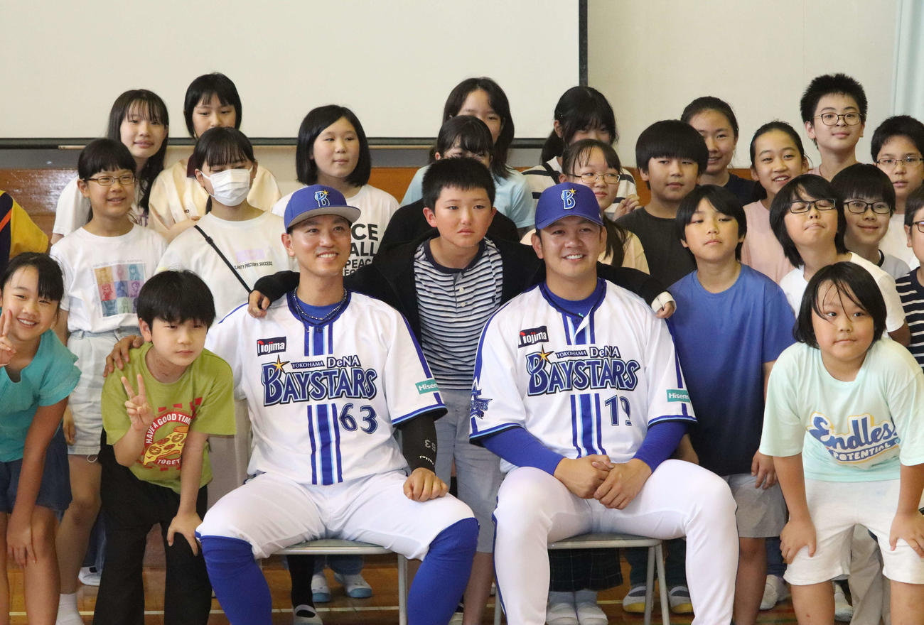 小学校をサプライズで訪問し、記念撮影するDeNA山崎（中央右）と関根（中央左）と感激のあまり泣きだす少年（中央）ら生徒たち（撮影・小早川宗一郎）