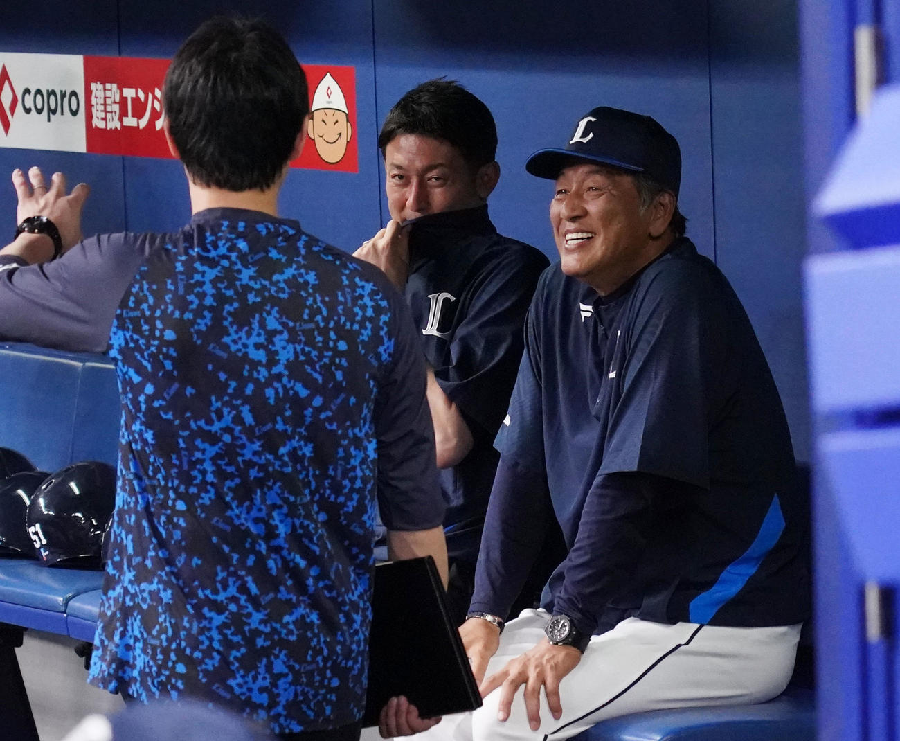 中日対西武　試合前、ベンチでスタッフと談笑する渡辺監督代行（右）（撮影・森本幸一）