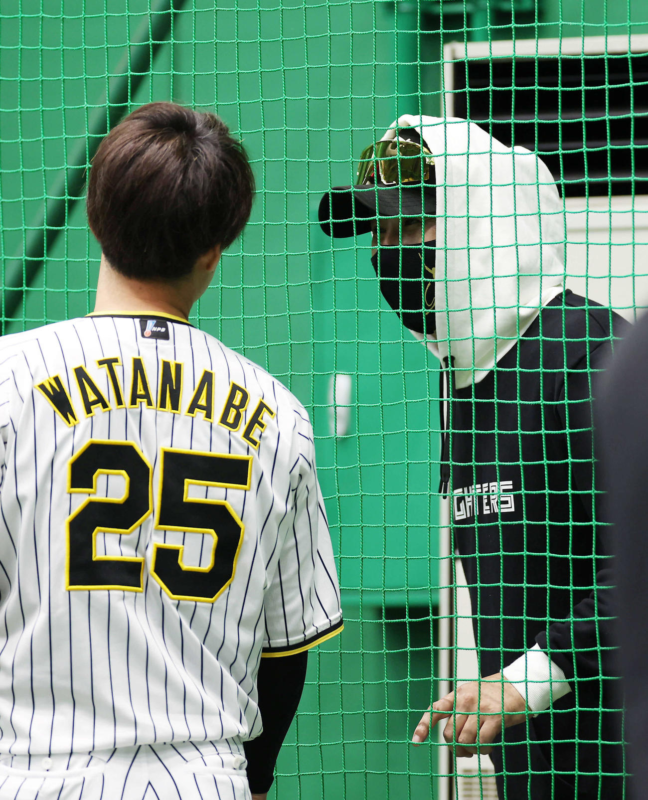 阪神対日本ハム　練習に顔を出した阪神渡辺（左）と言葉を交わす日本ハム新庄監督（撮影・前田充）