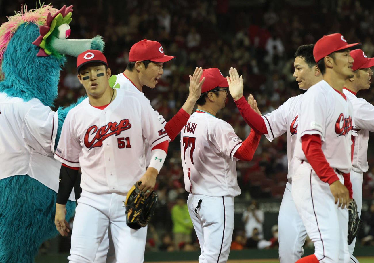 広島対オリックス　ナインを迎える新井監督（左から2人目）（撮影・加藤孝規）