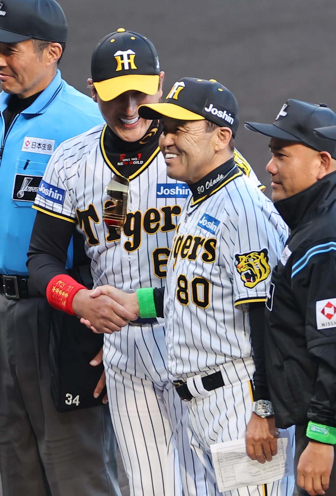 阪神対日本ハム　阪神のユニホームで登場した新庄監督（左）は岡田監督と笑顔で握手を交わす（撮影・上田博志）
