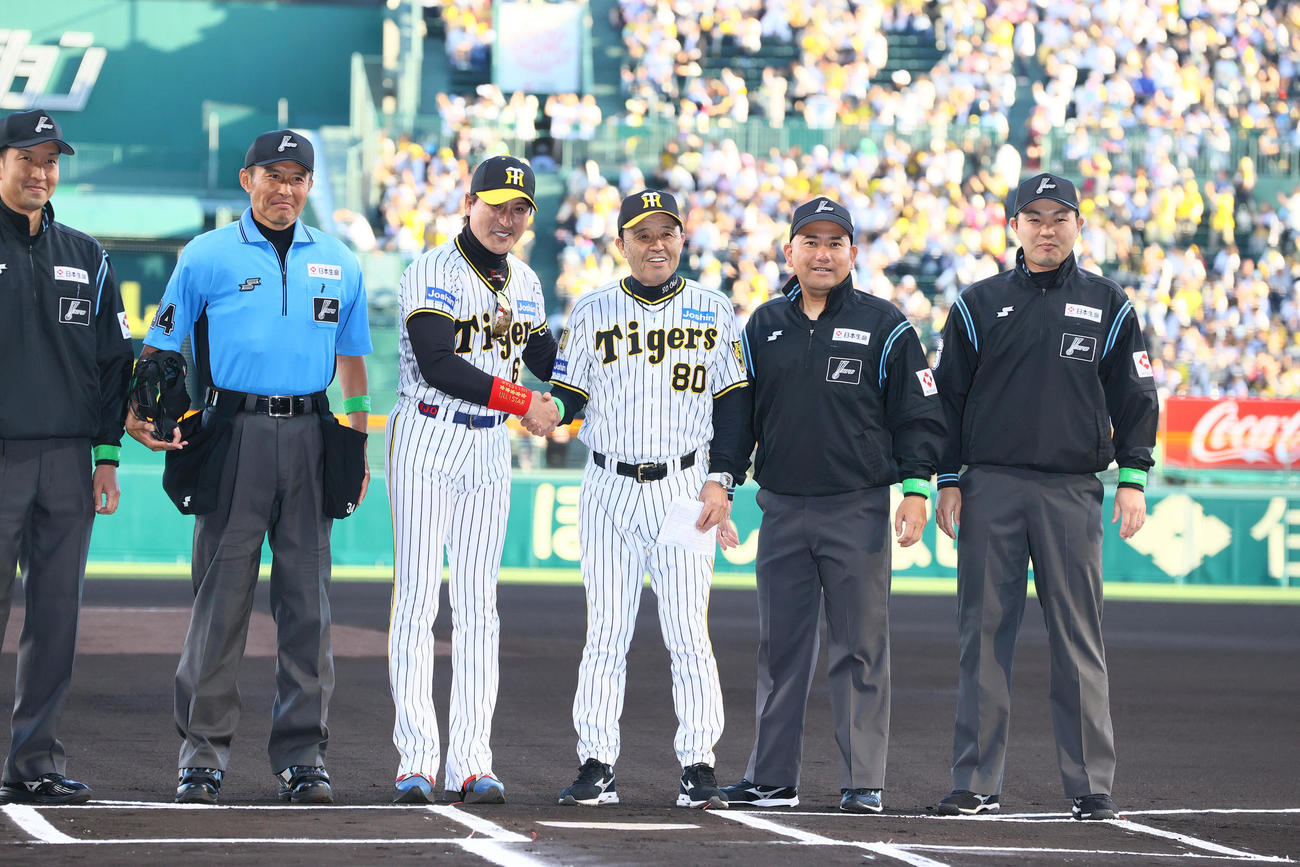 阪神対日本ハム　試合前のメンバー表交換で日本ハム新庄監督（左）は阪神のユニホームを着て阪神岡田監督と握手をかわす（撮影・上山淳一