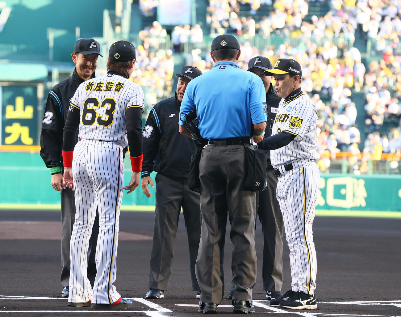 阪神対日本ハム　試合前のメンバー表最終確認で日本ハム新庄監督（左）は阪神のユニホームを着て登場する。右は阪神岡田監督（撮影・上山淳一）