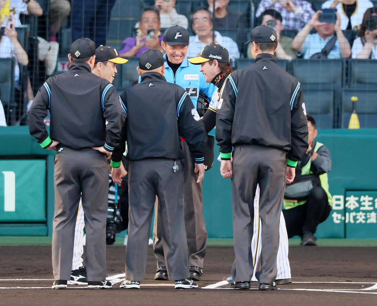 阪神対日本ハム　メンバー表の最終最終確認に阪神のユニホーム姿で登場し岡田監督（左）と握手する新庄監督（撮影・加藤哉）