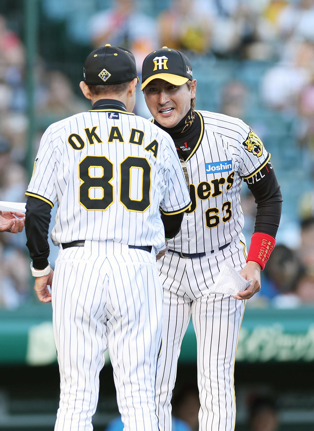 阪神対日本ハム　阪神岡田監督（左）とのメンバー表最終確認に阪神のユニホーム姿で登場する日本ハム新庄監督（撮影・前田充）