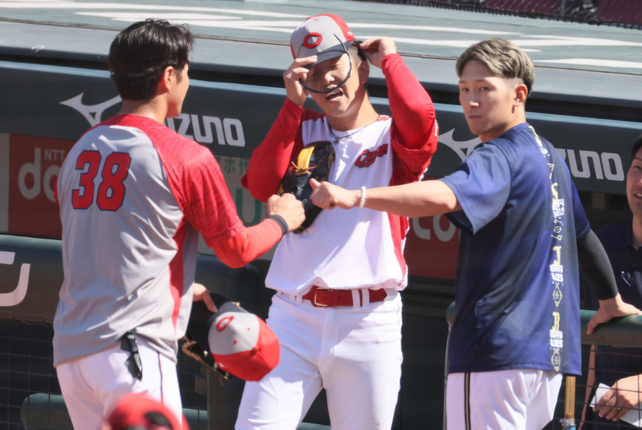広島対オリックス　試合前練習中、広島宇草（左）とグータッチするオリックス西川（右）。中央は小園（撮影・加藤孝規）
