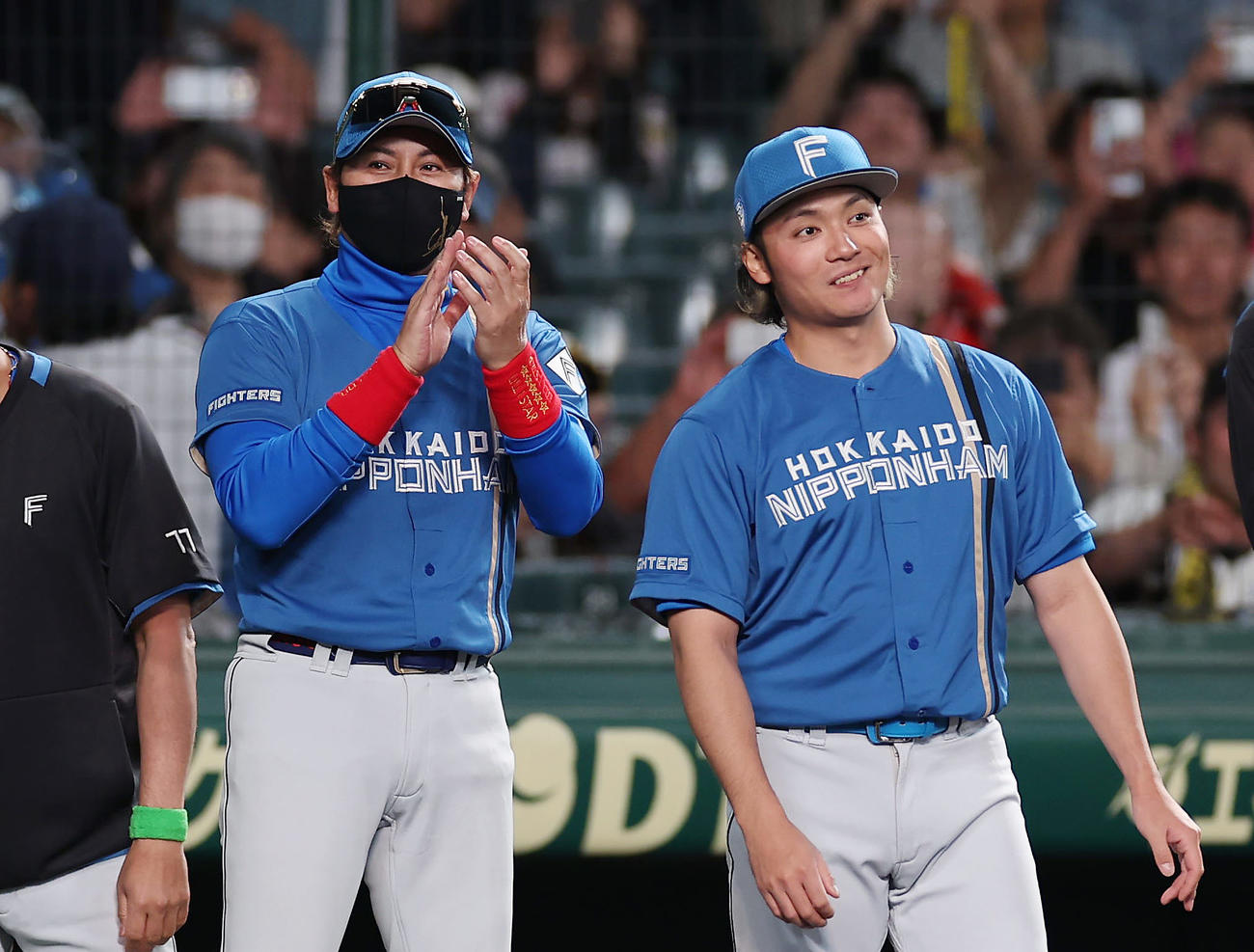阪神対日本ハム　阪神に勝利し、拍手でナインを出迎える日本ハム新庄監督。右は伊藤（撮影・前田充）