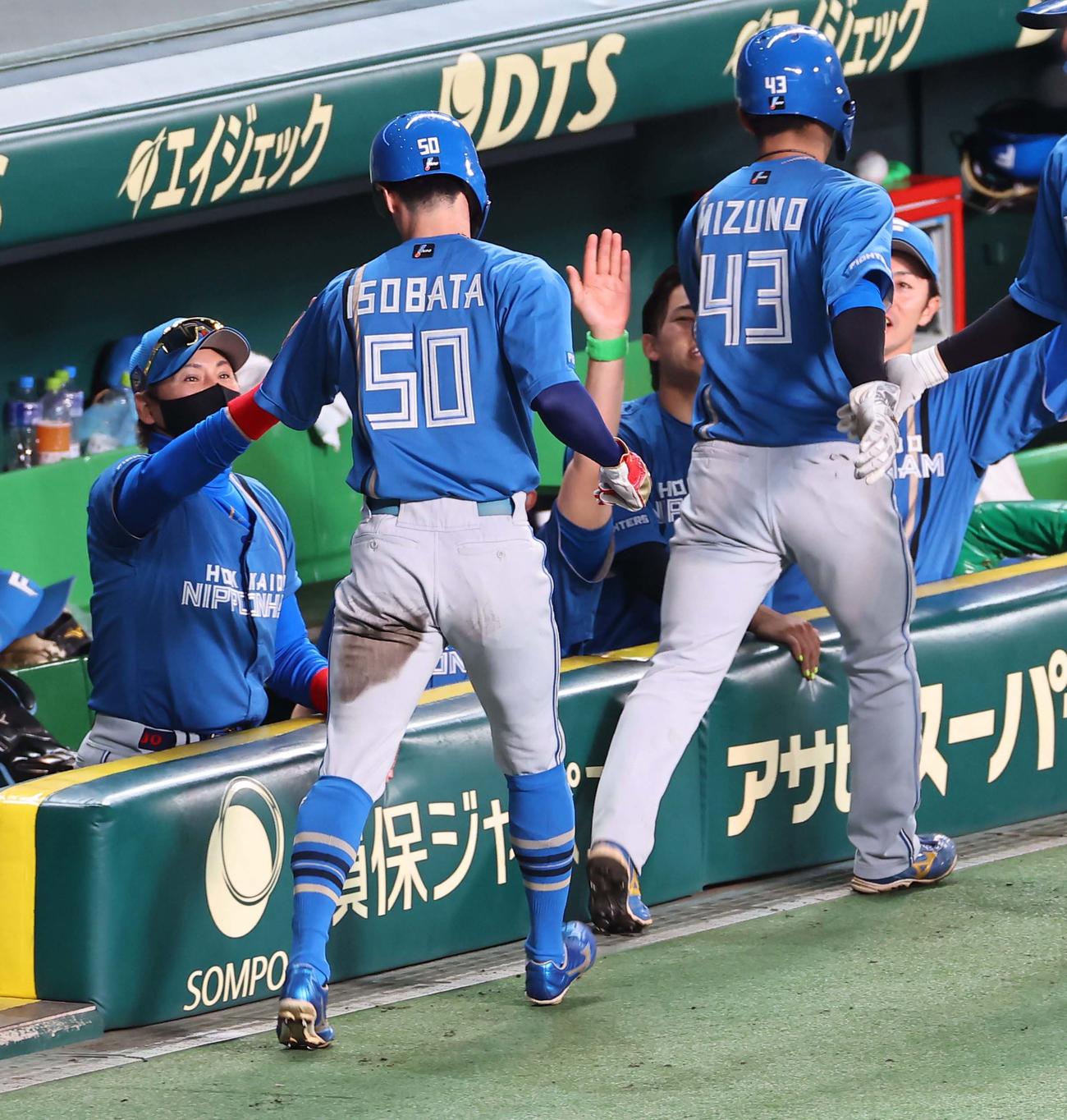 阪神対日本ハム　7回表日本ハム1死二、三塁、新庄監督（左）は水谷の適時打で生還した五十幡と水野を出迎える（撮影・上田博志）