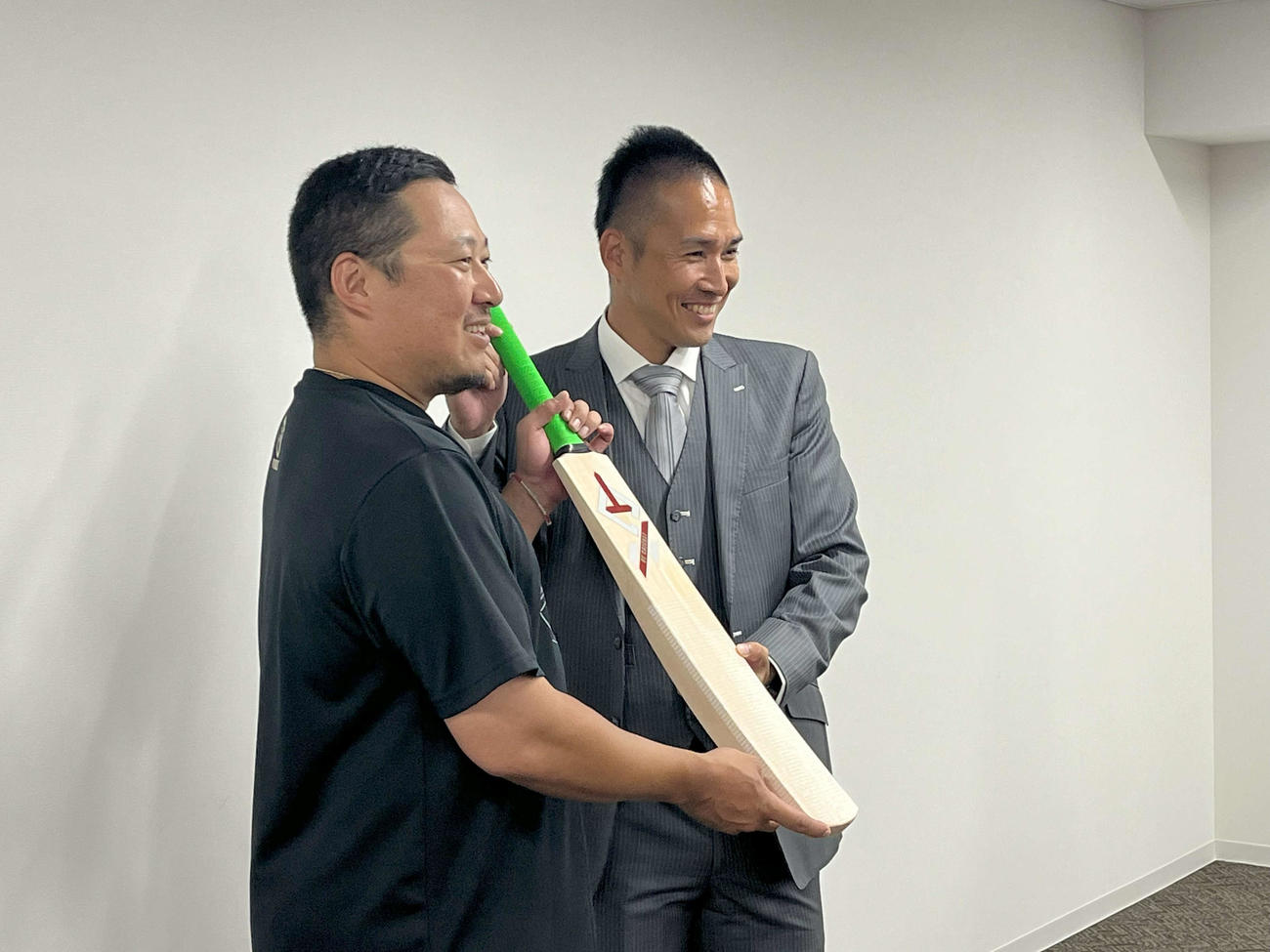 クリケットのバットを贈呈する広島OBでクリケット選手の木村昇吾（右）と広島松山竜平外野手（左）