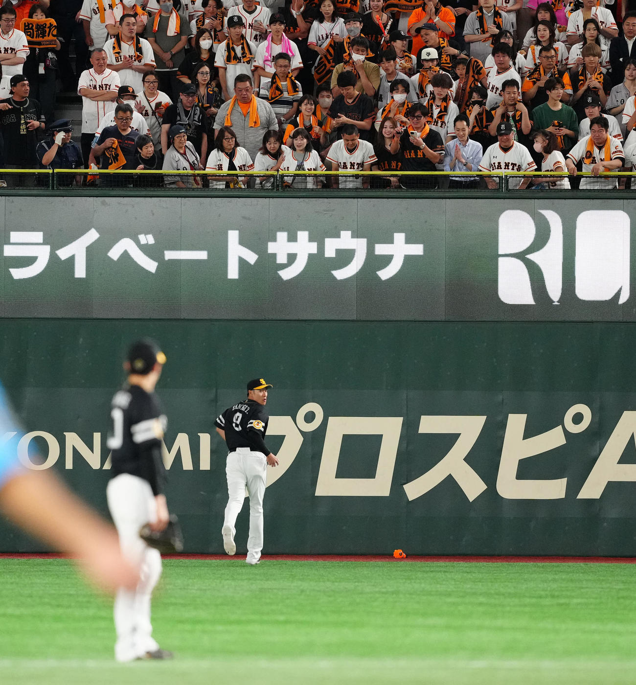 巨人対ソフトバンク　3回裏、巨人ファンが落とした応援グッズを拾いに向かうソフトバンク右翼手柳田（撮影・江口和貴）