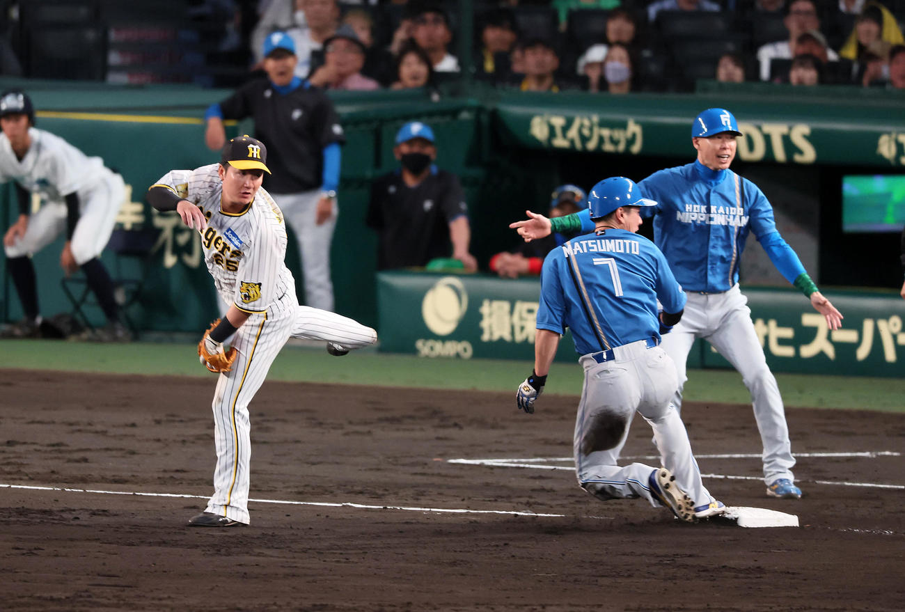 阪神対日本ハム　4回表日本ハム無死一、二塁、渡辺（左）は伏見の投前バントを処理した西勇からの悪送球を後逸する（撮影・加藤哉）