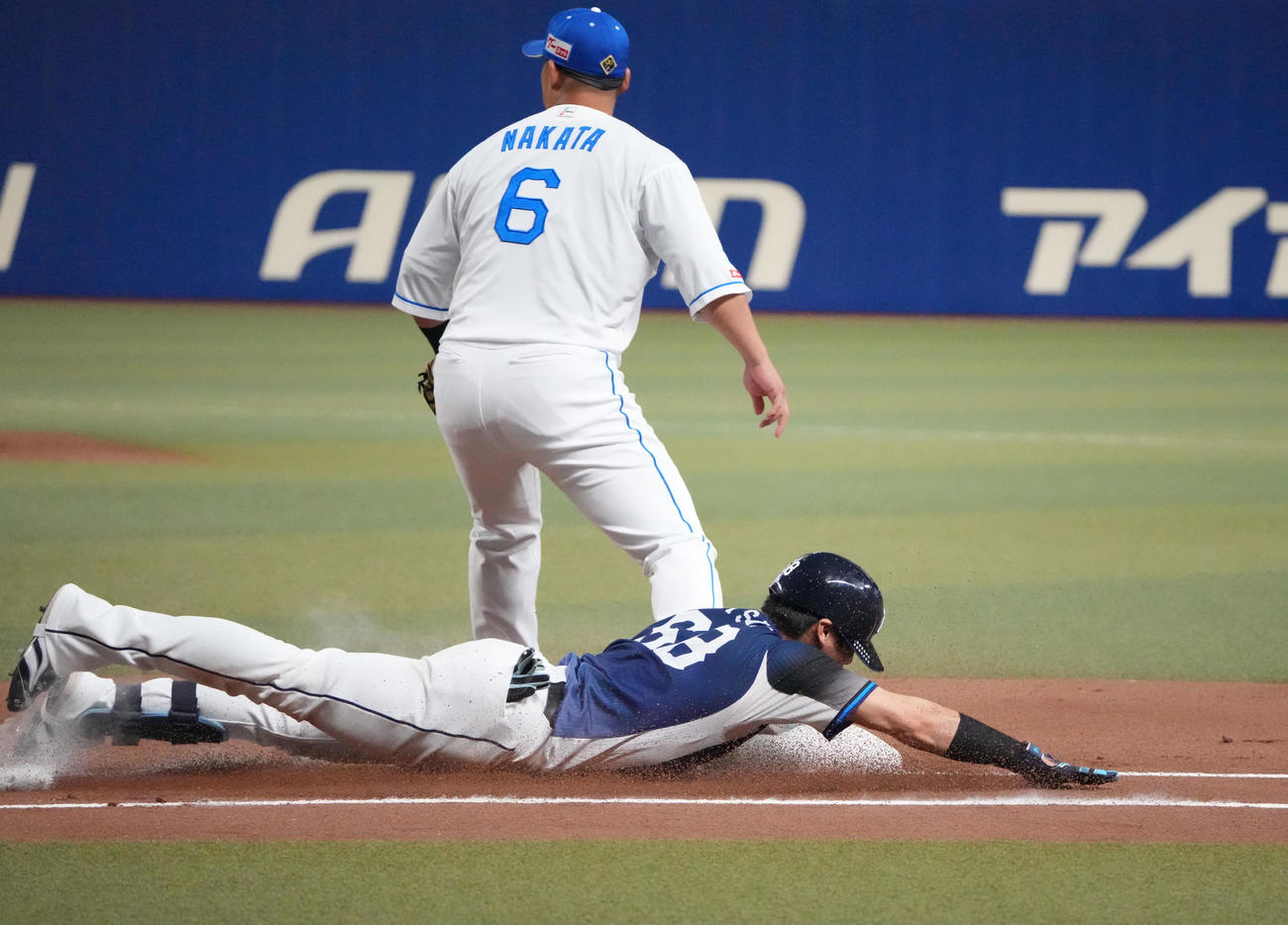 中日対西武　1回表西武1死満塁、先制の遊ゴロを放ち一塁へヘッドスライディングする岸（手前）（撮影・森本幸一）