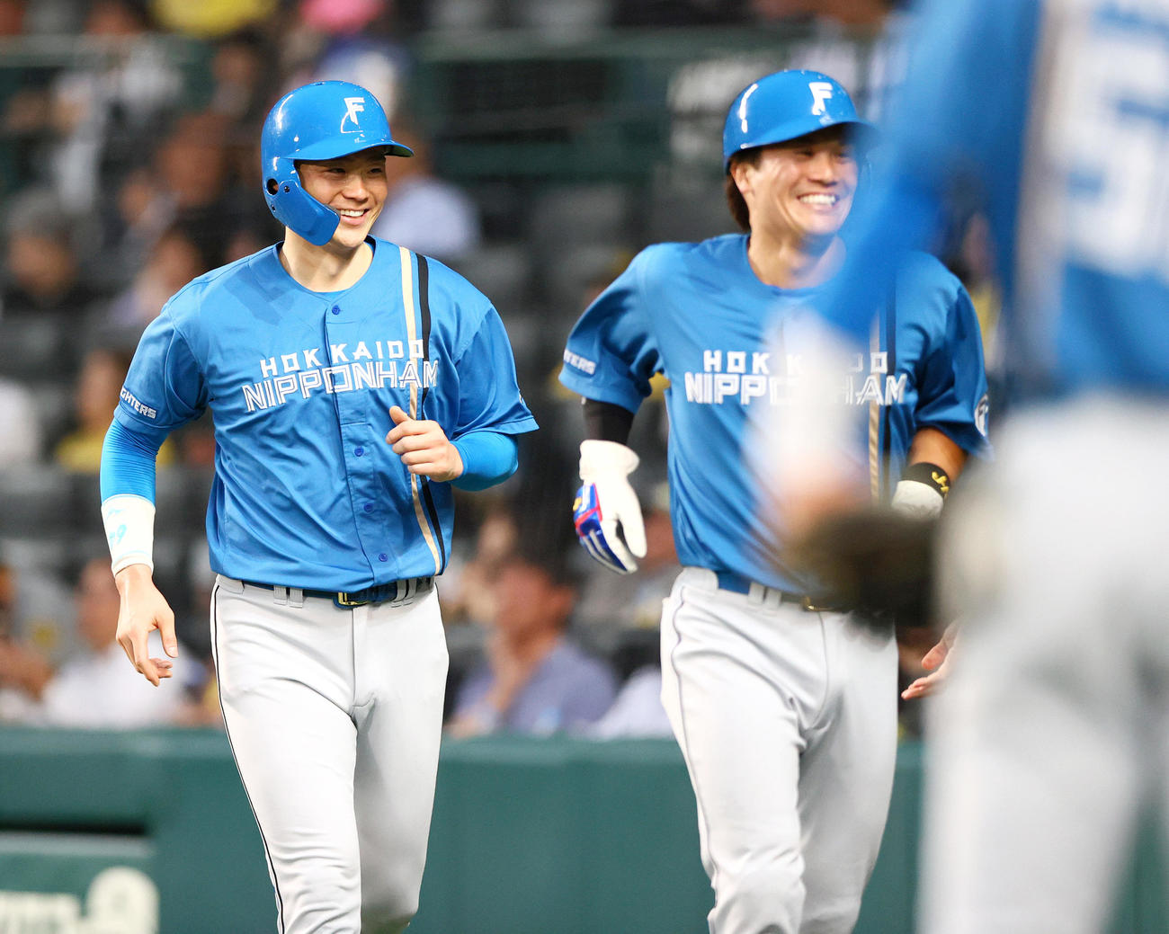 阪神対日本ハム　4回表日本ハム無死二、三塁、山崎（左）と伏見は水野の右前適時打で生還し笑顔を見せる（撮影・上山淳一）