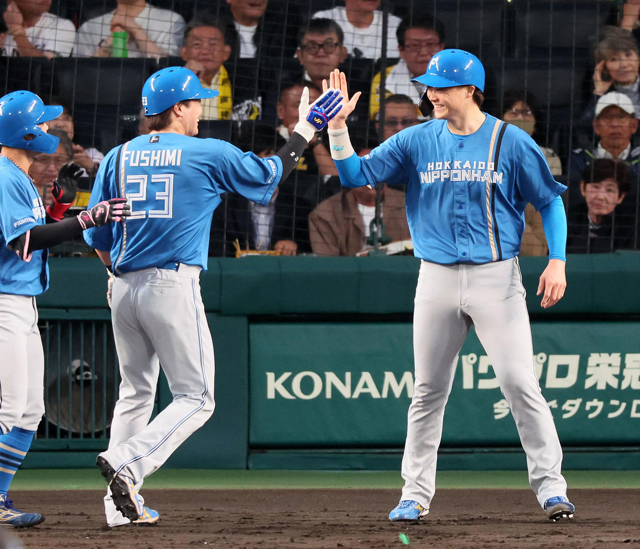 阪神対日本ハム　4回表日本ハム無死二、三塁、水野の右適時打で生還しタッチする伏見（左）と山崎（撮影・加藤哉）