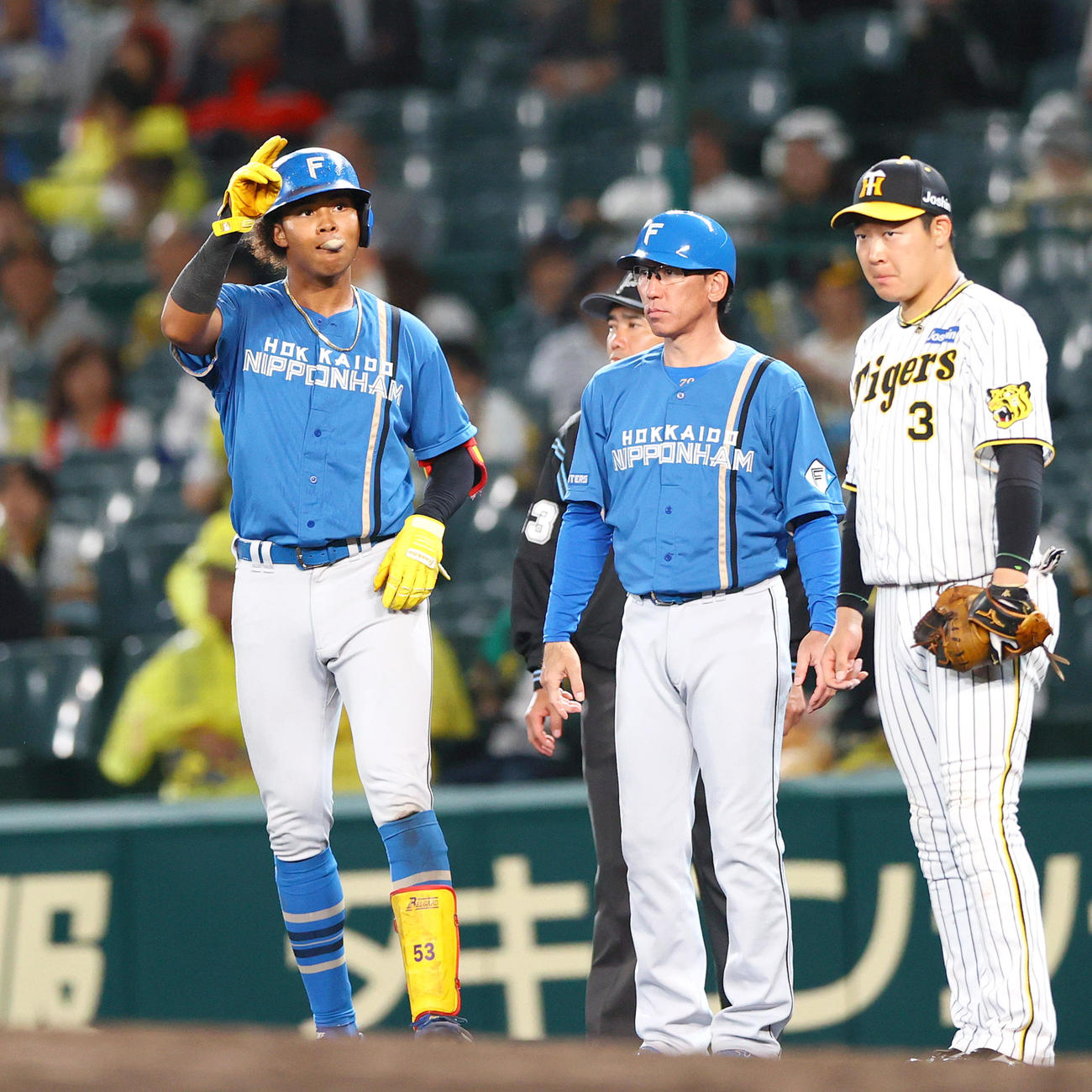 阪神対日本ハム　9回表日本ハム無死、水谷（左）は左前打を放ち一塁でベンチへ向かってポーズする（撮影・上山淳一）