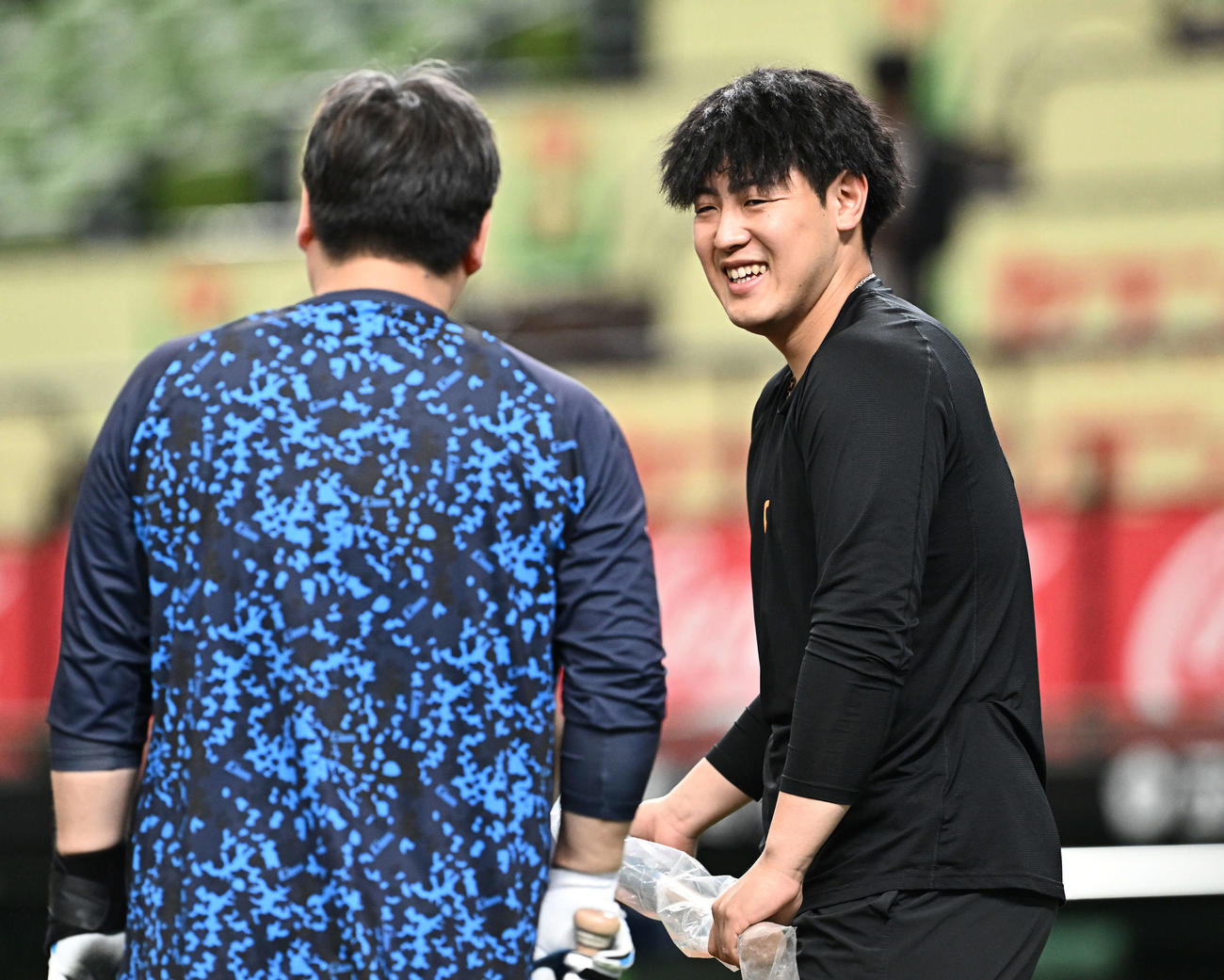西武対巨人　試合前練習で西武中村剛（左）からバットを受け取り笑顔の巨人岡本和（撮影・滝沢徹郎）