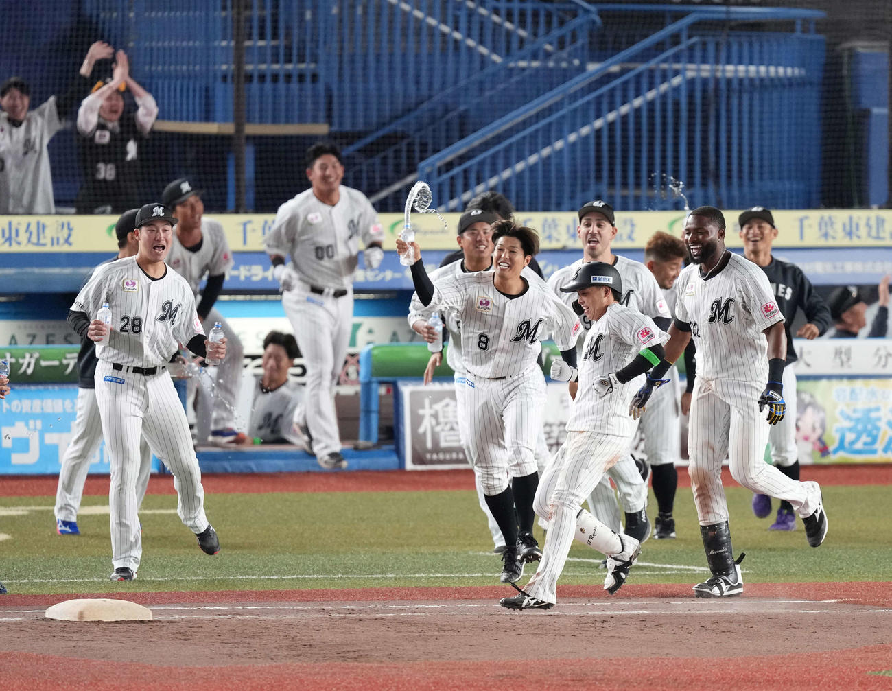 ロッテ対阪神　延長10回裏ロッテ2死満塁、小川はサヨナラの押し出し四球を選び歓喜のナインから祝福を受ける（撮影・小沢裕）