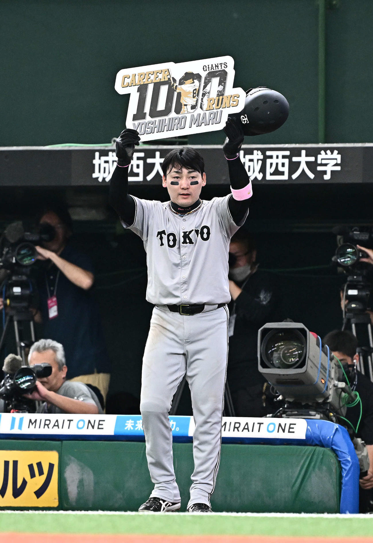 西武対巨人　5回表、1000得点を達成した巨人丸は記念のボードを手にする（撮影・滝沢徹郎）