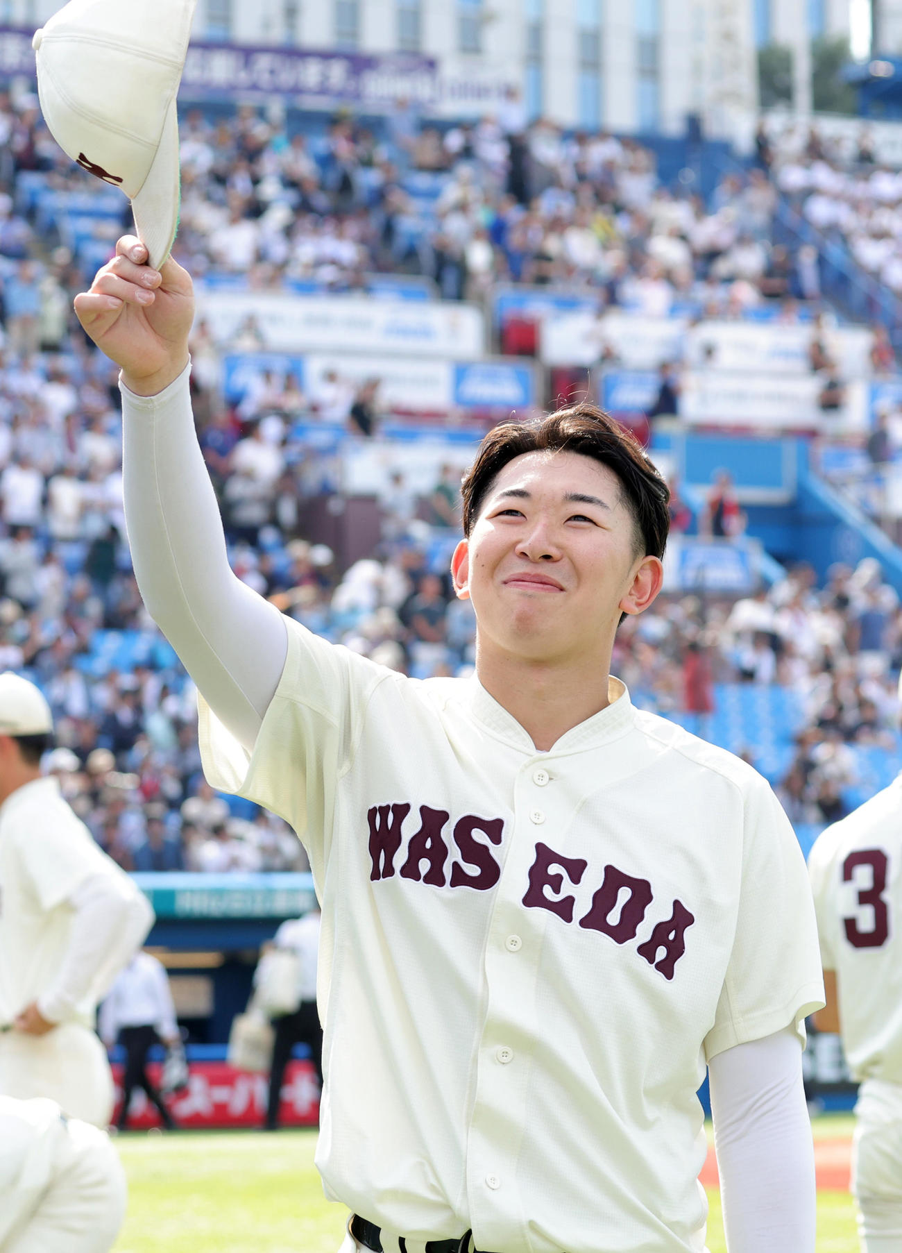 慶大対早大　8回3安打1失点で勝利となり、笑顔で応援席の祝福に応える早大・伊藤樹（撮影・野上伸悟）